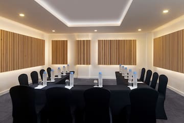 a room with black chairs and black tablecloths