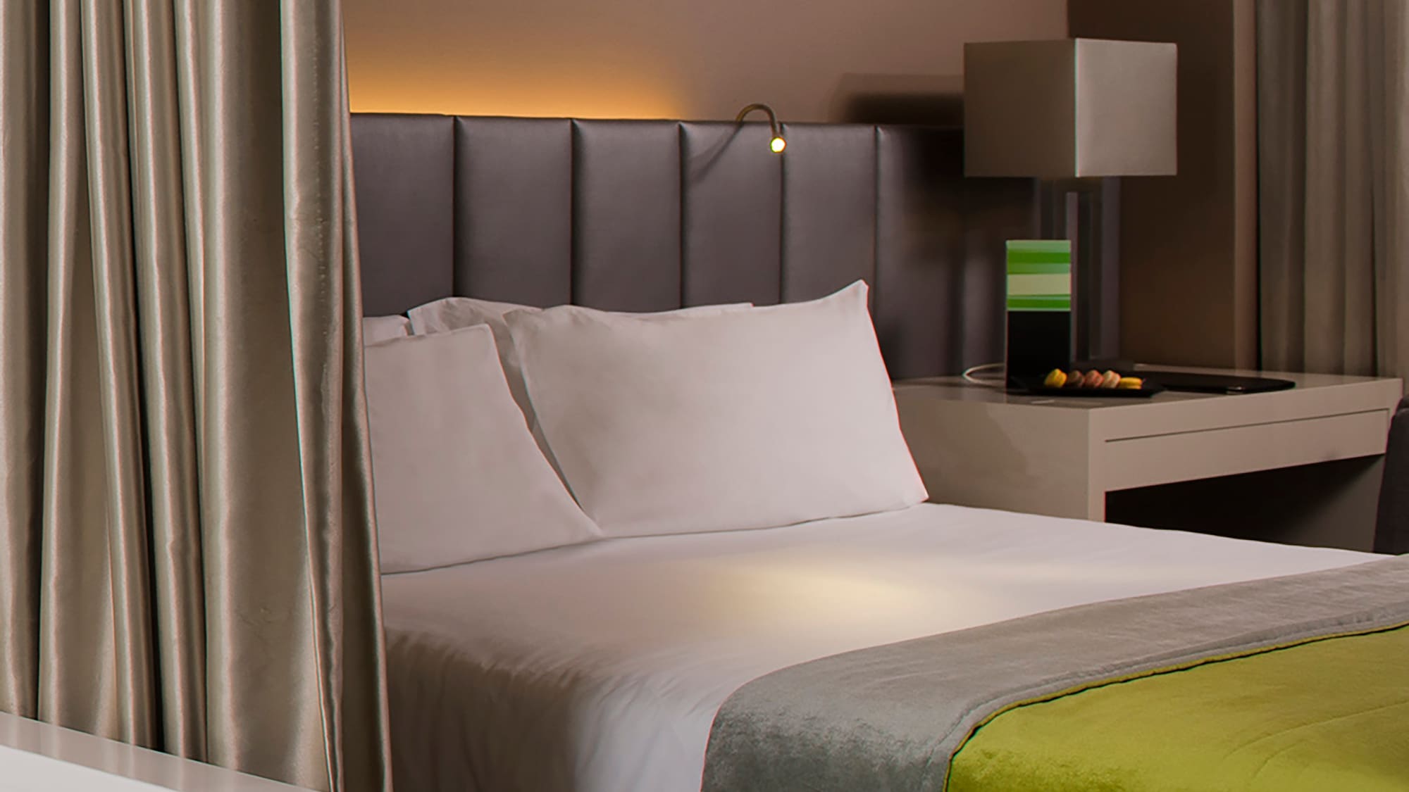 a bed with a green and yellow blanket