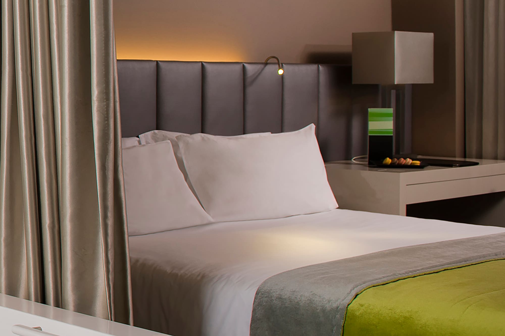 a bed with a green and yellow blanket