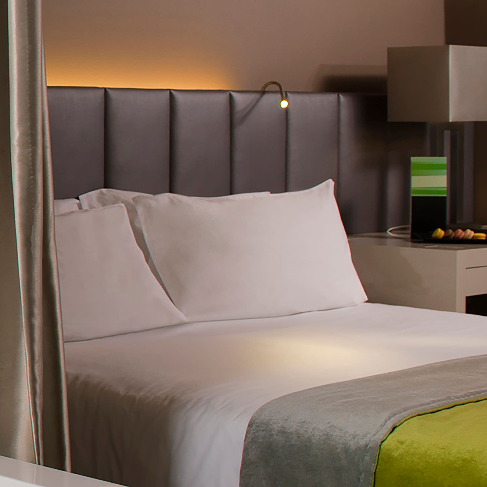 a bed with a green and yellow blanket