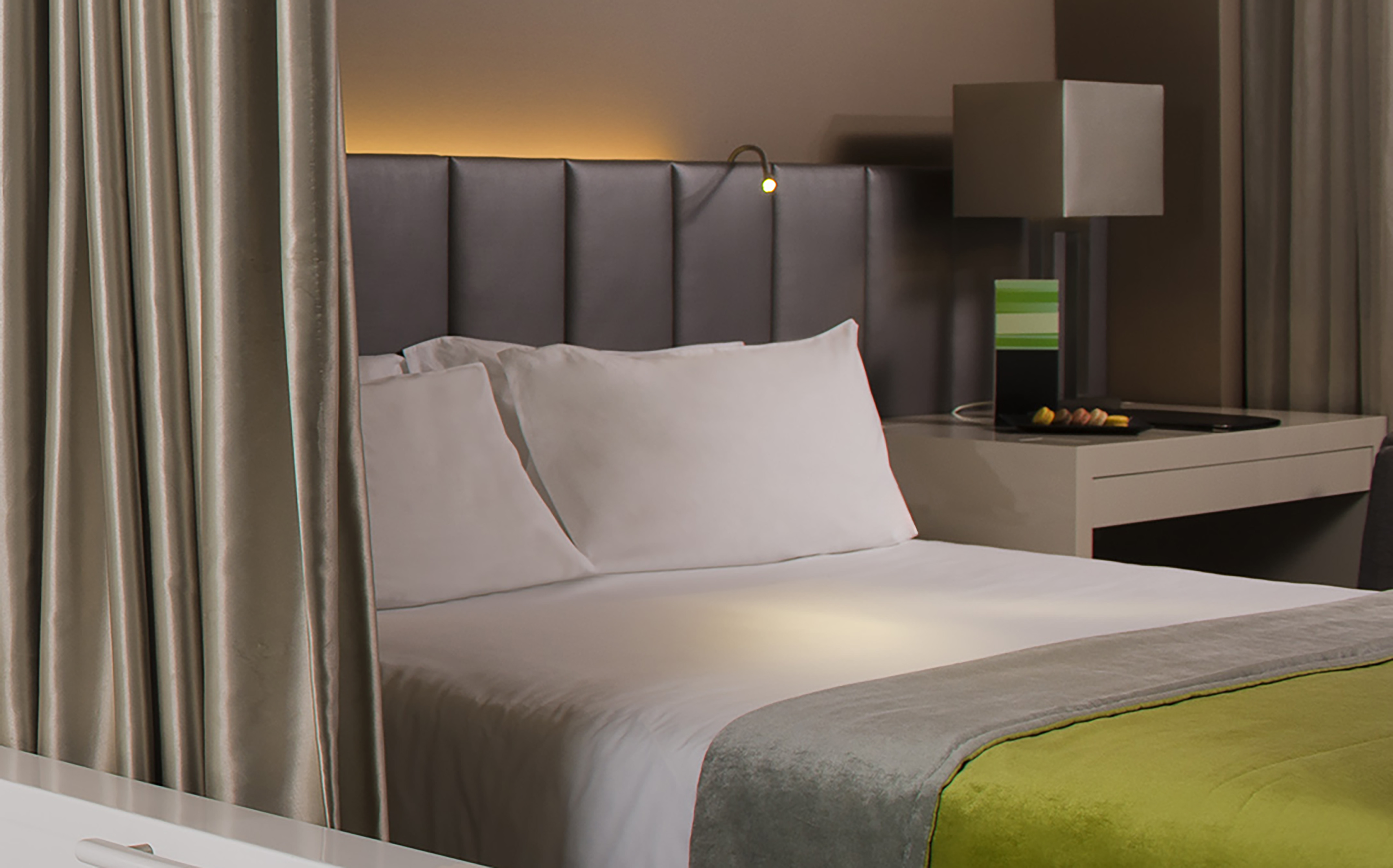 a bed with a green and yellow blanket