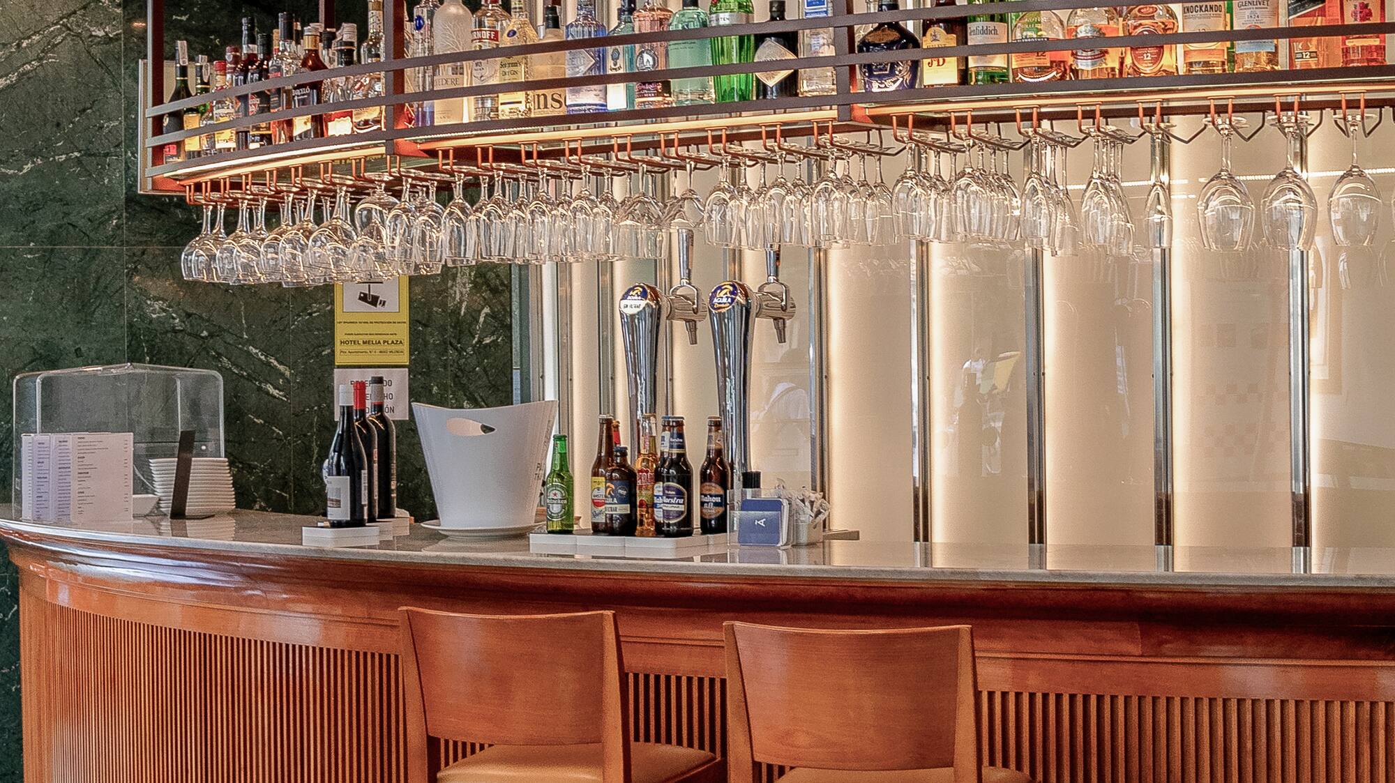 a bar with wine glasses over the bar