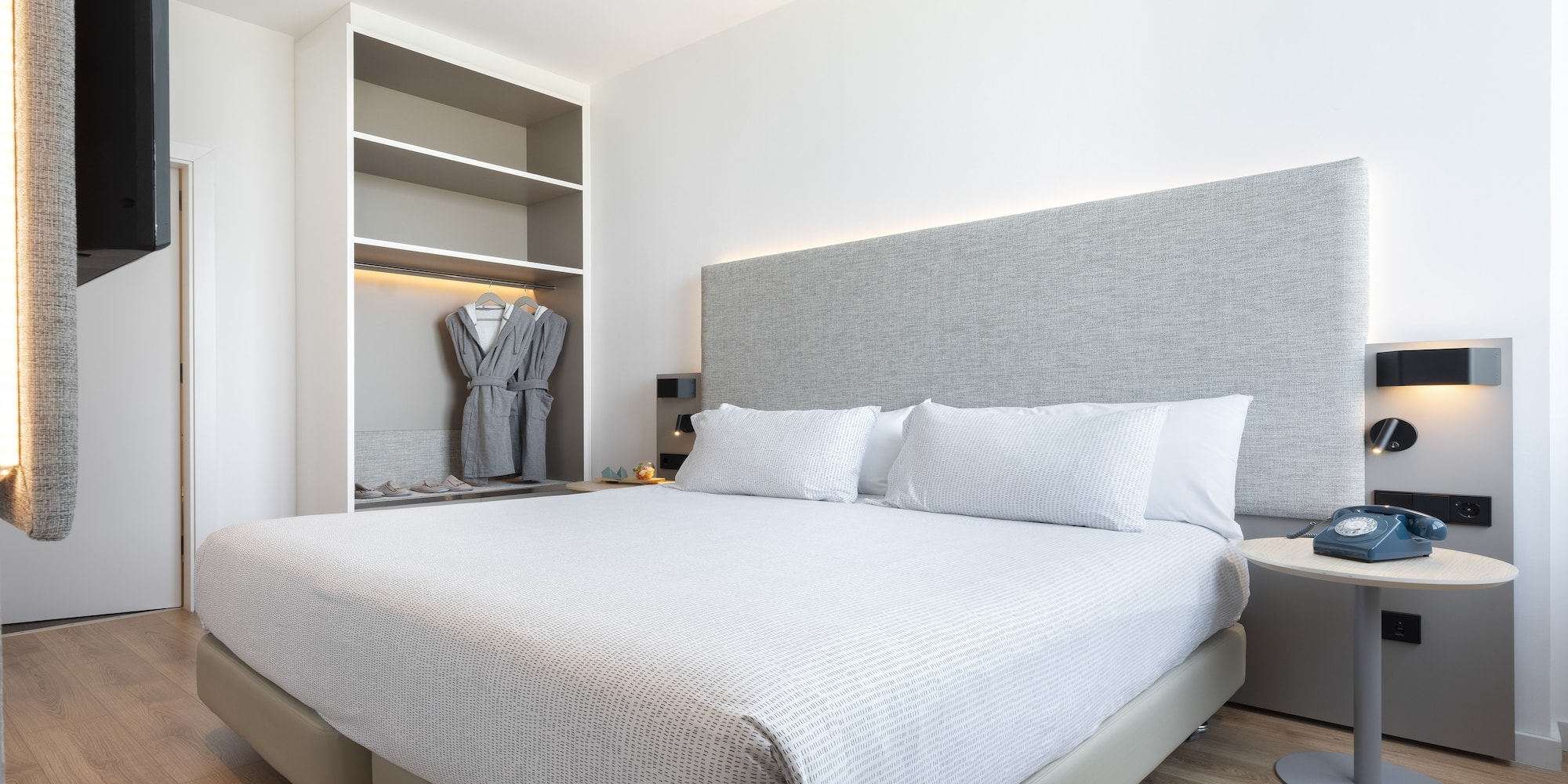 a bed with a white cover and a gray headboard