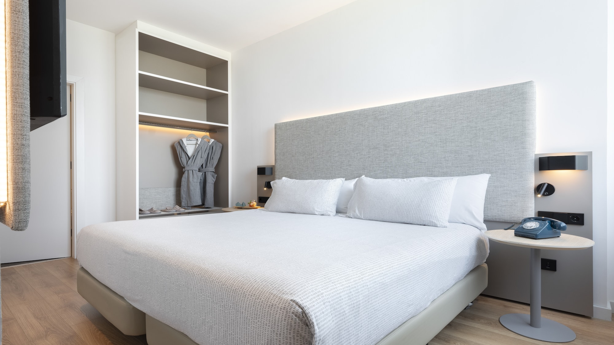 a bed with a white cover and a gray headboard