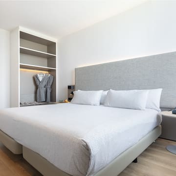 a bed with a white cover and a gray headboard