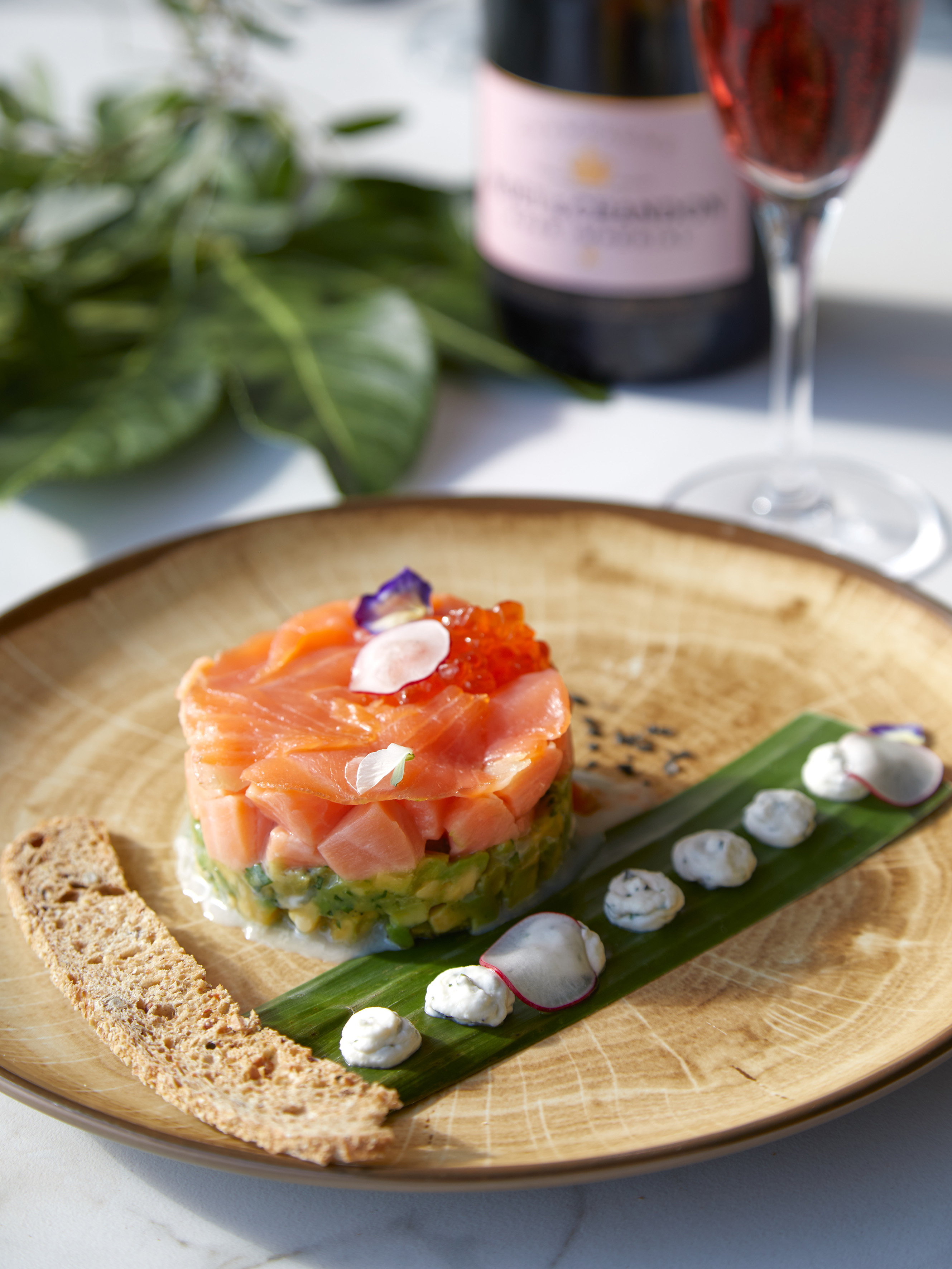 Salmon and avocado tartare with caviar, crisp, and rosé champagne.