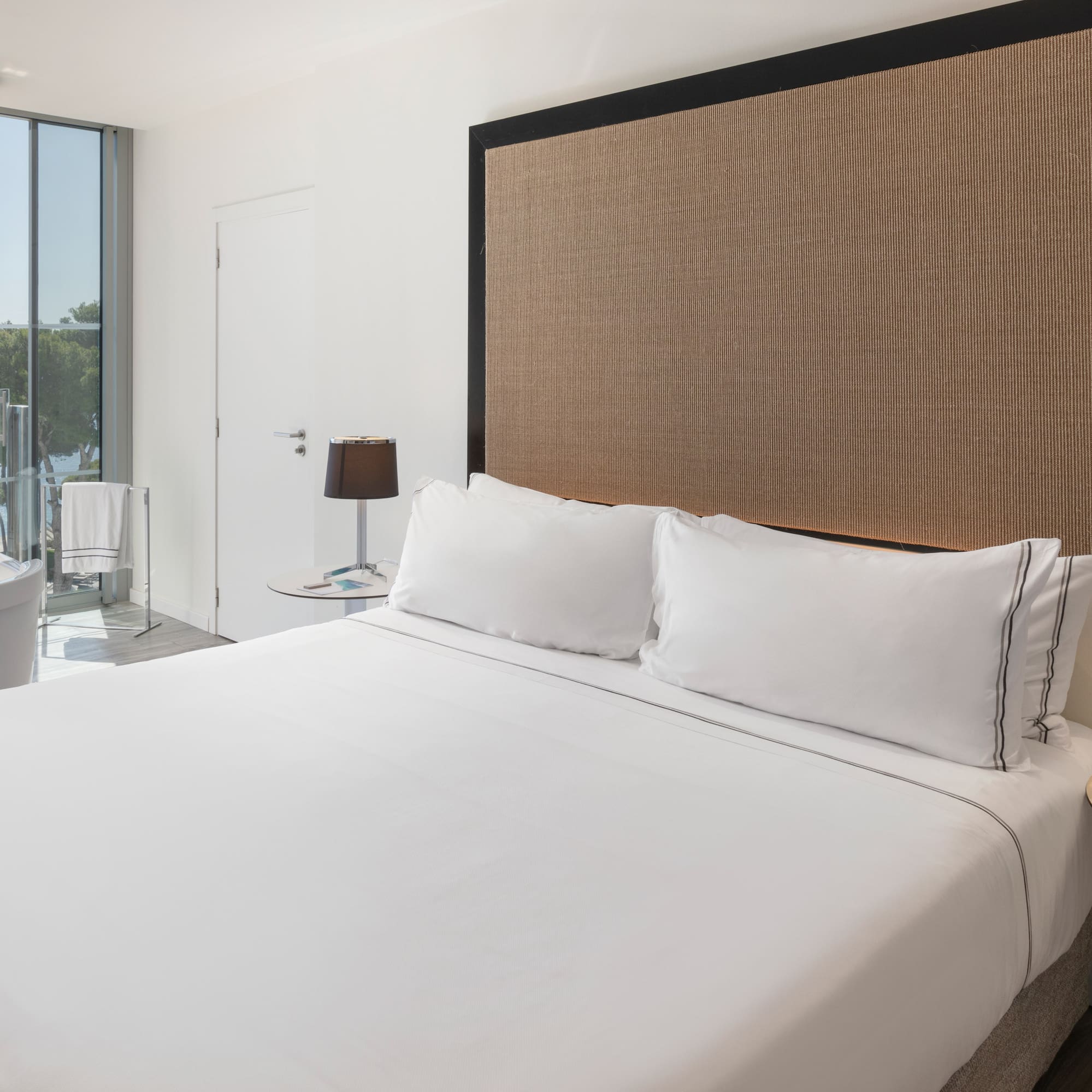 a bed with white sheets and a brown headboard