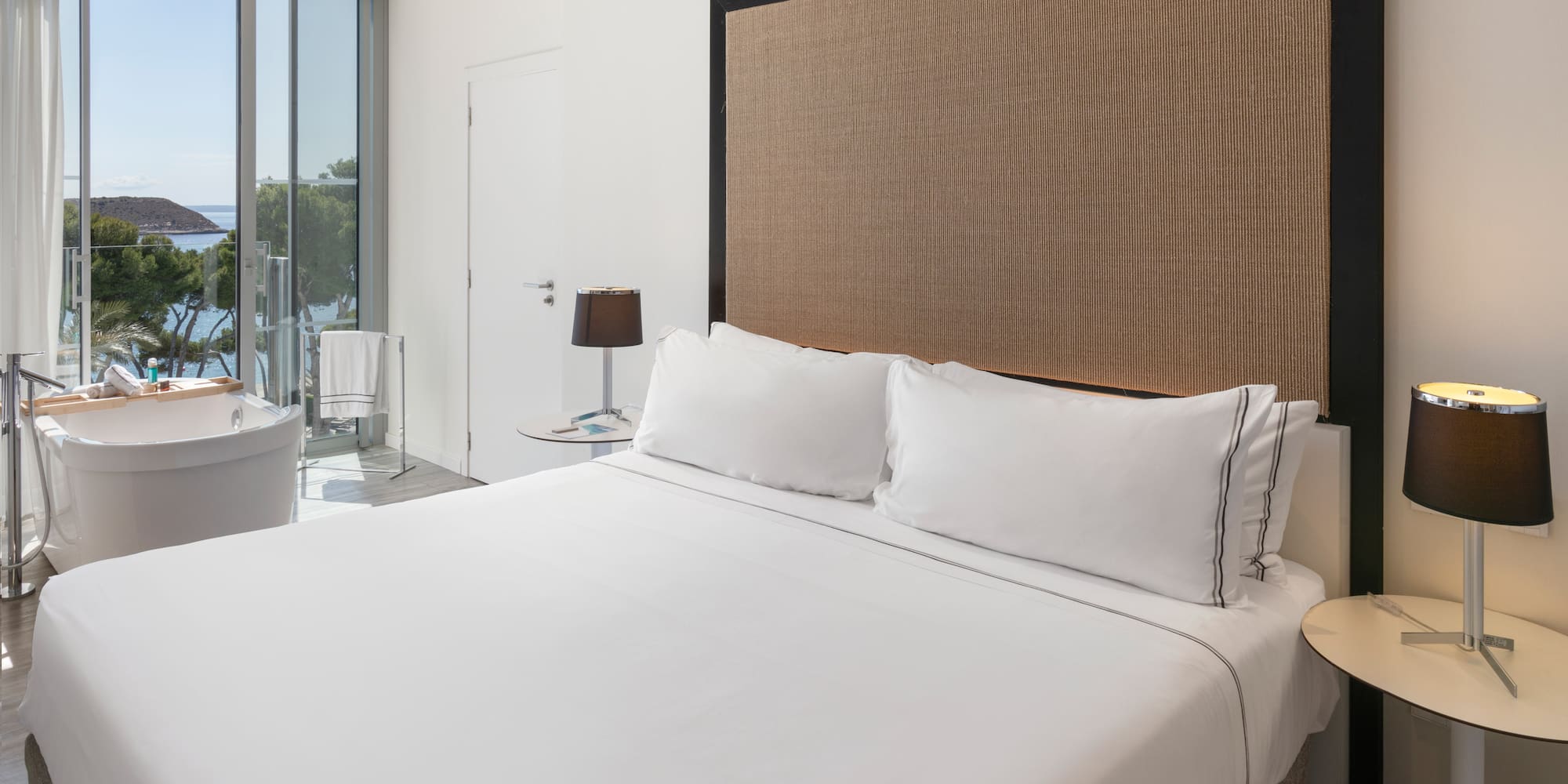 a bed with white sheets and a brown headboard