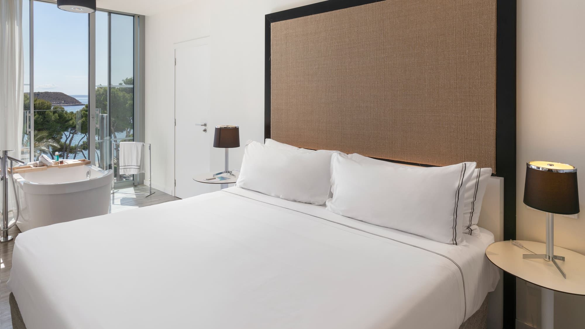 a bed with white sheets and a brown headboard