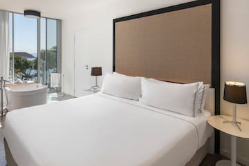 a bed with white sheets and a brown headboard