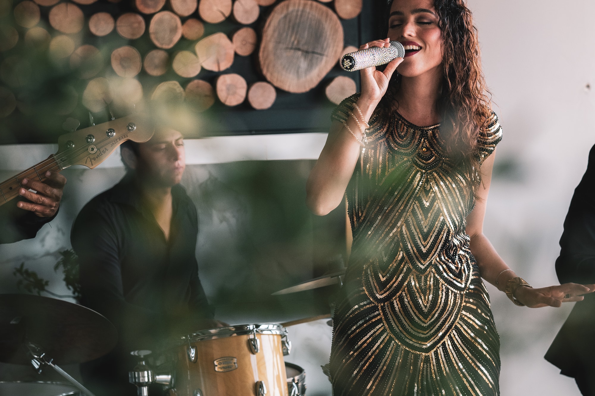 a woman singing into a microphone while a band plays