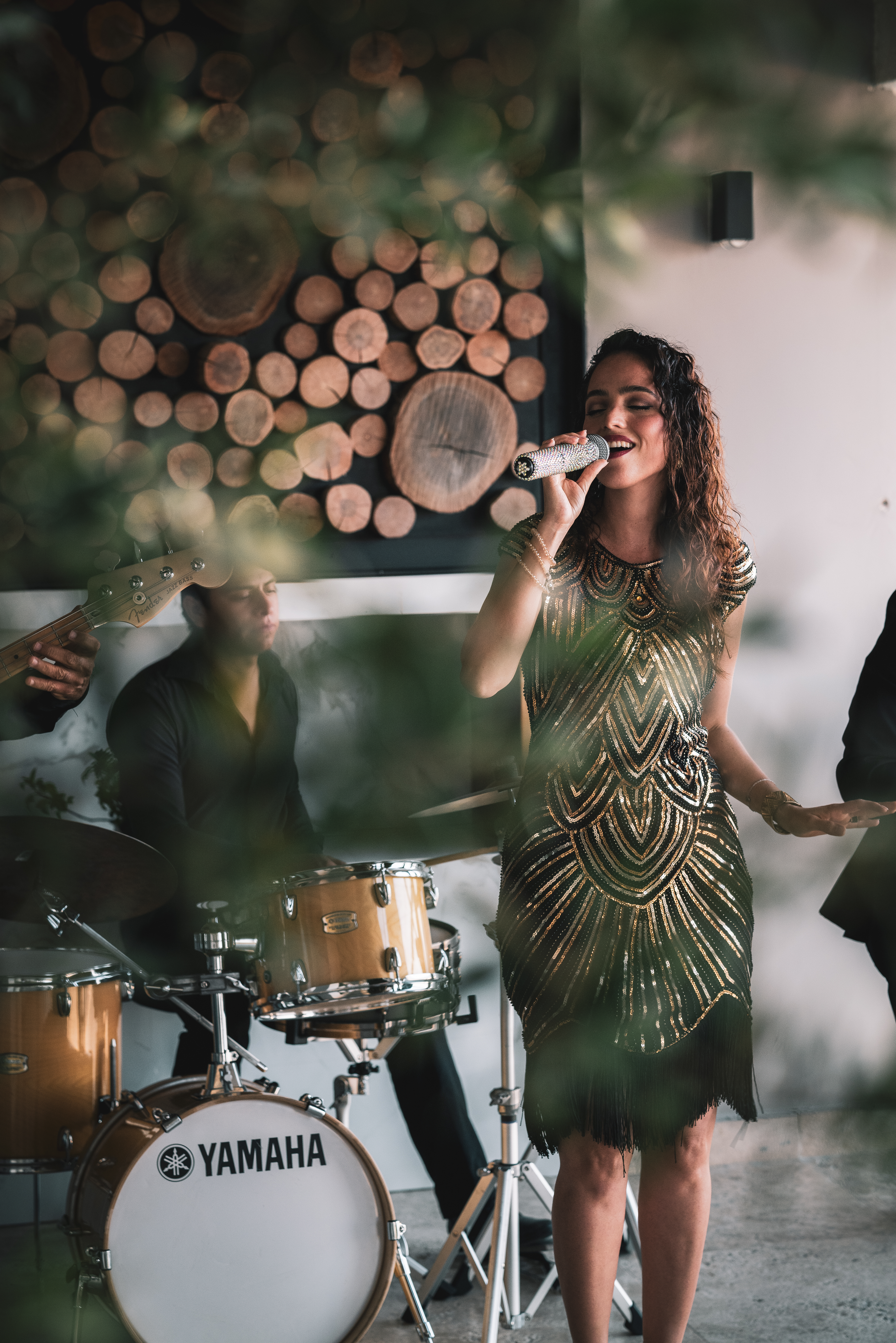 a woman singing into a microphone while a band plays