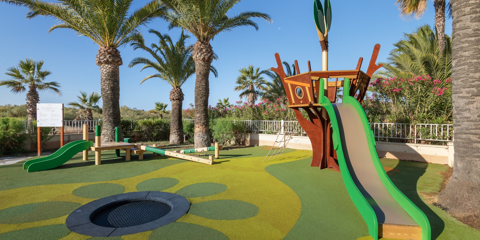 a playground with a slide and a trampoline