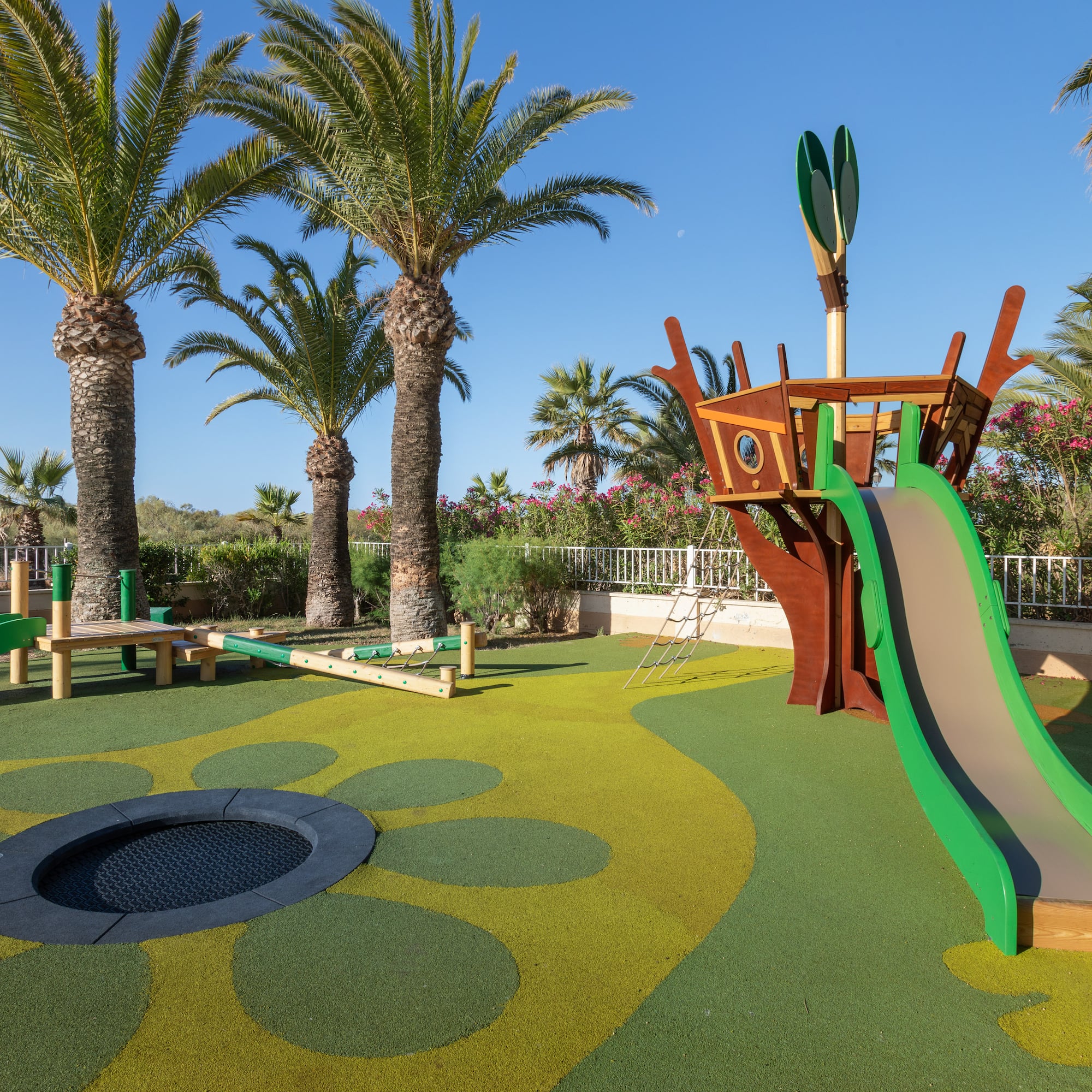 a playground with a slide and a trampoline