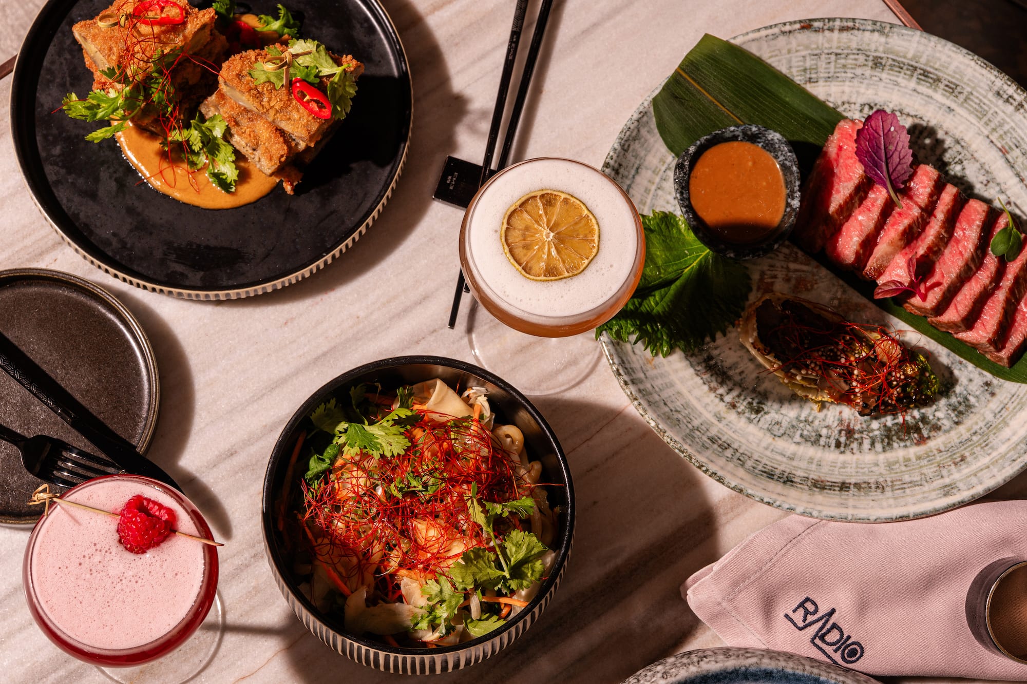 Asian fine dining: rare beef, crispy dish, fresh salad, and craft cocktails.