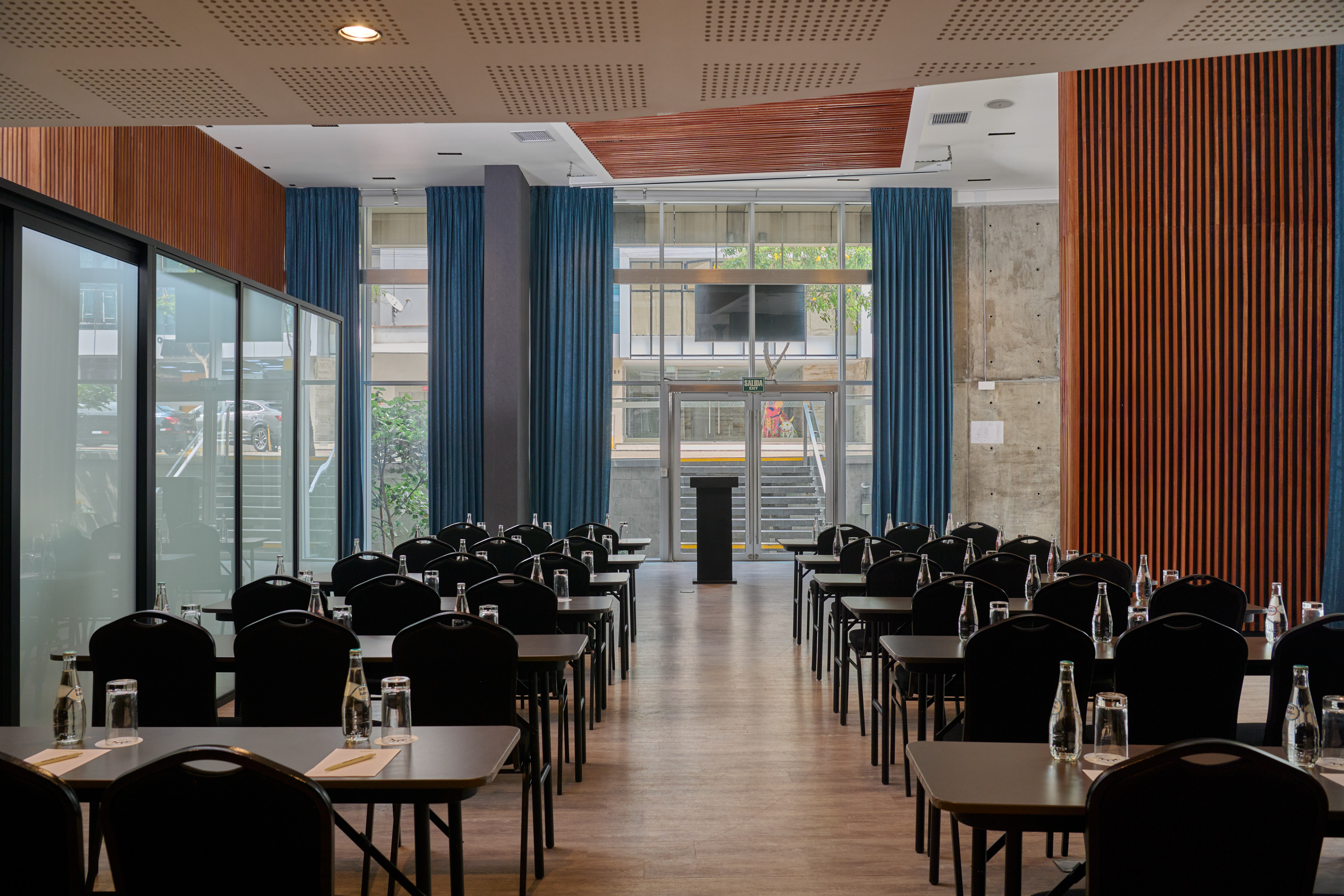 Modern empty meeting room with tables, chairs, and a central podium.