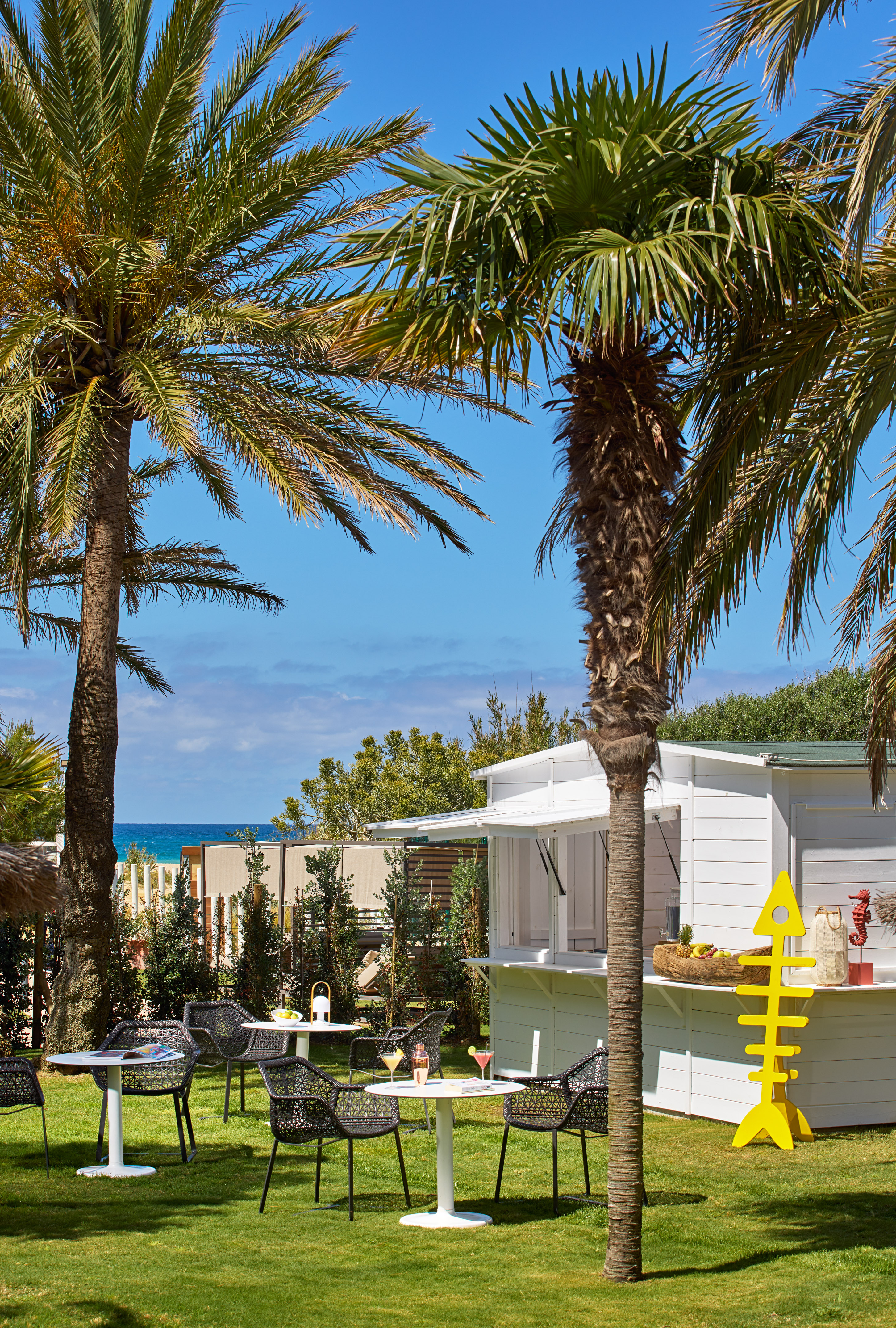 a white house with palm trees and a bar