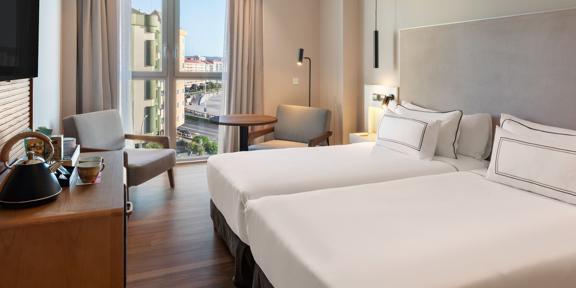 a room with two beds and a desk and chair