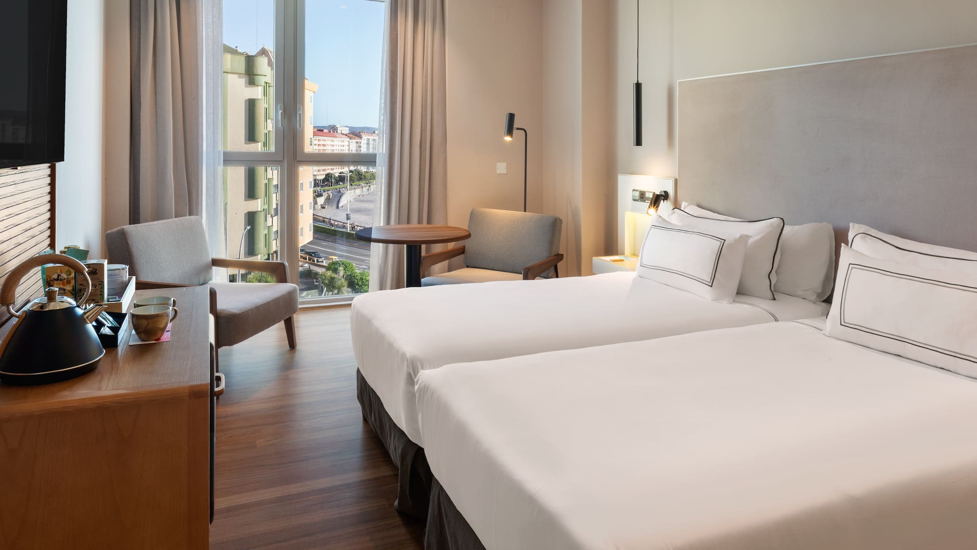 a room with two beds and a desk and chair