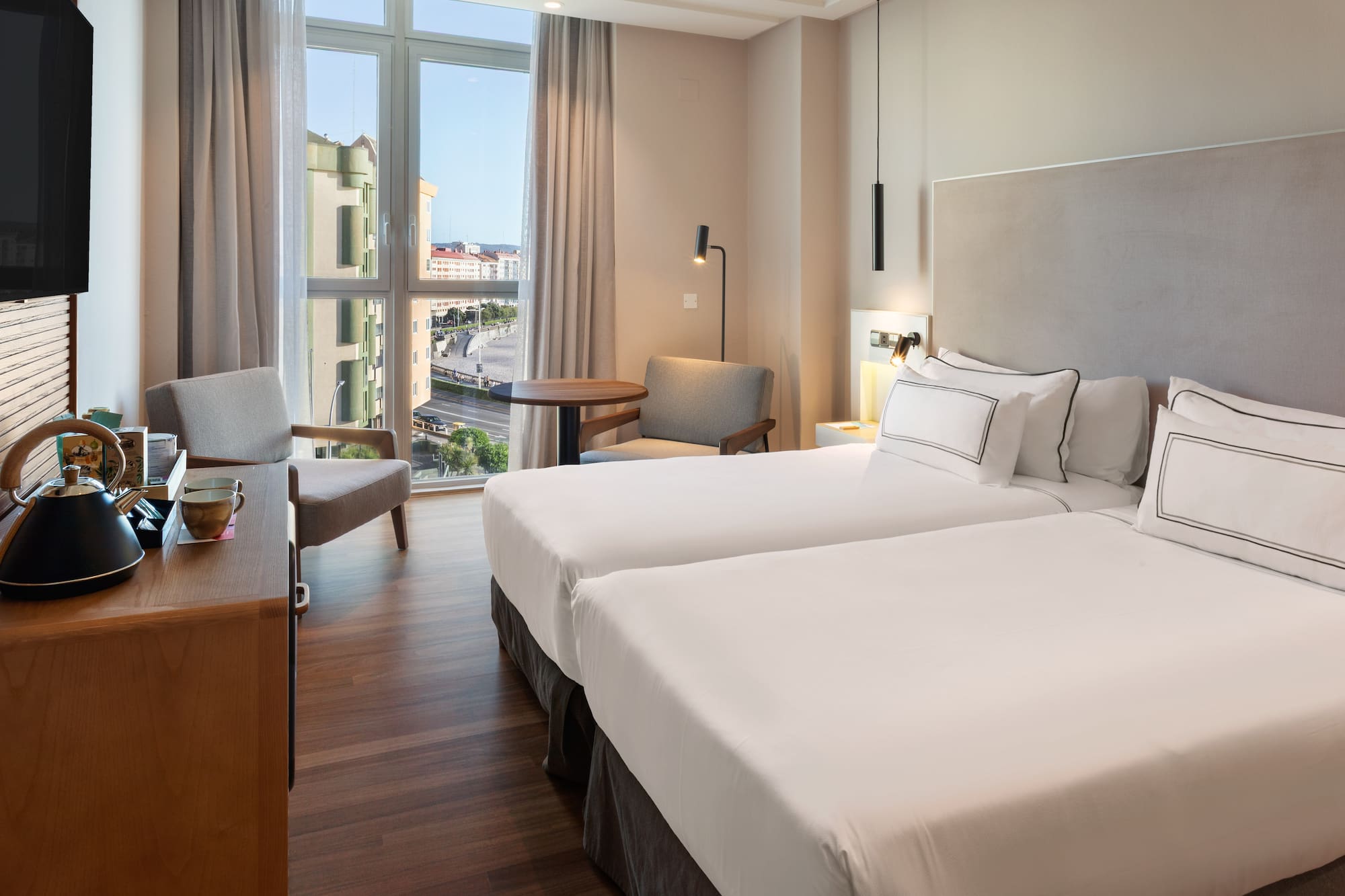 a room with two beds and a desk and chair