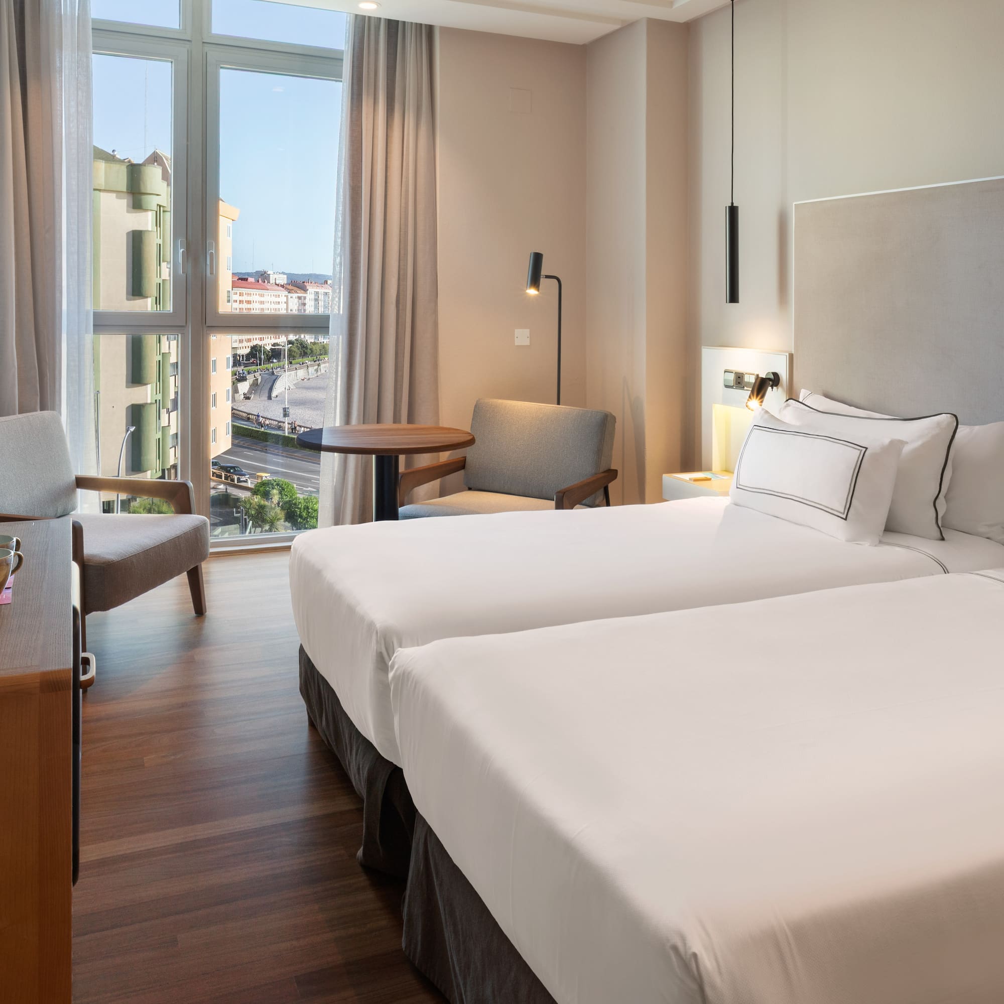 a room with two beds and a desk and chair