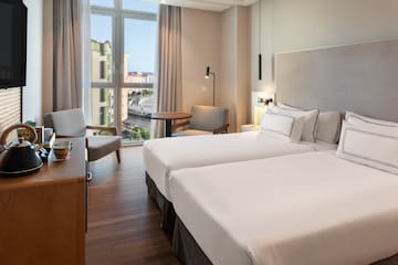 a room with two beds and a desk and chair