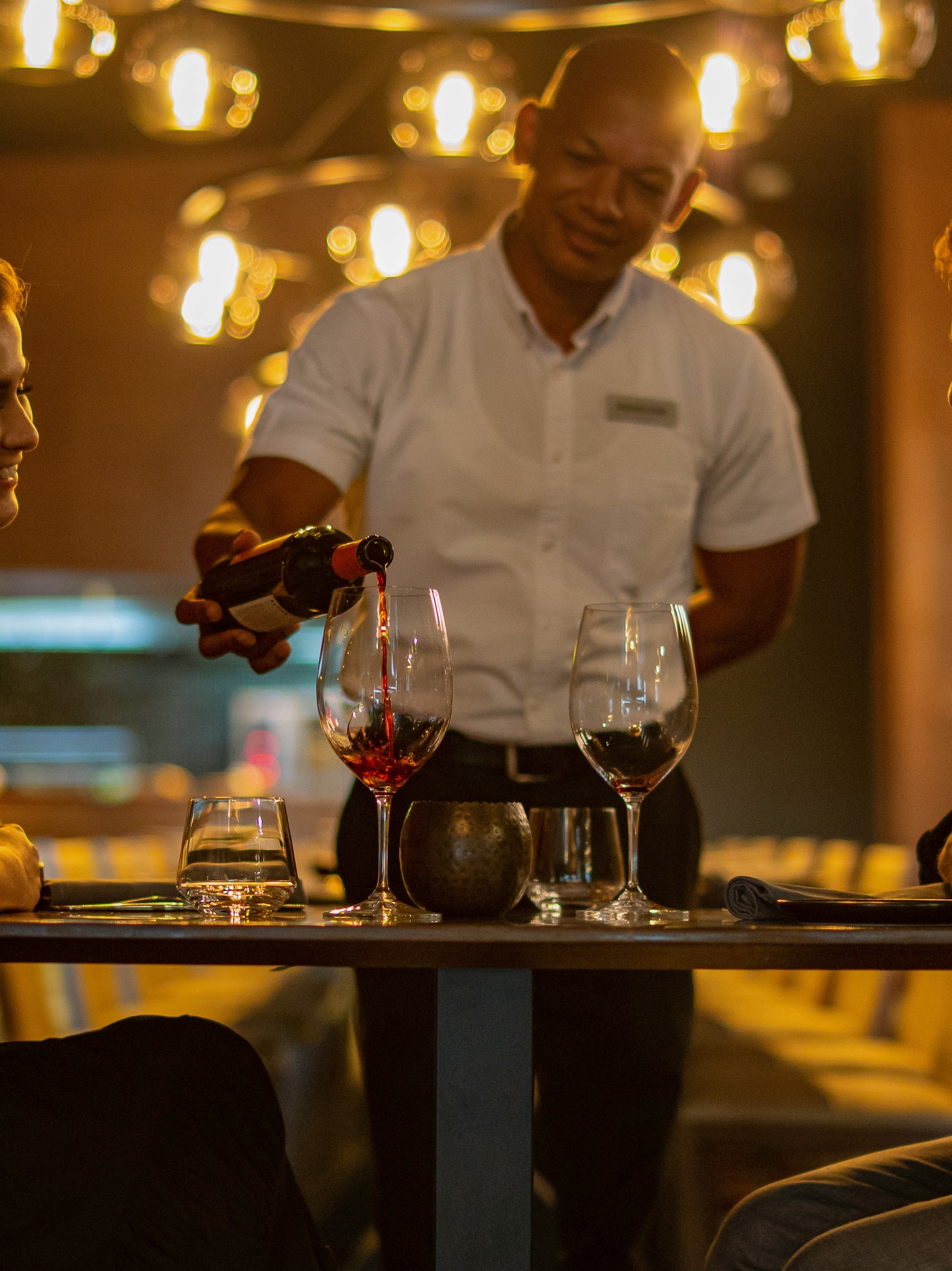 a man pouring wine into a woman's glass