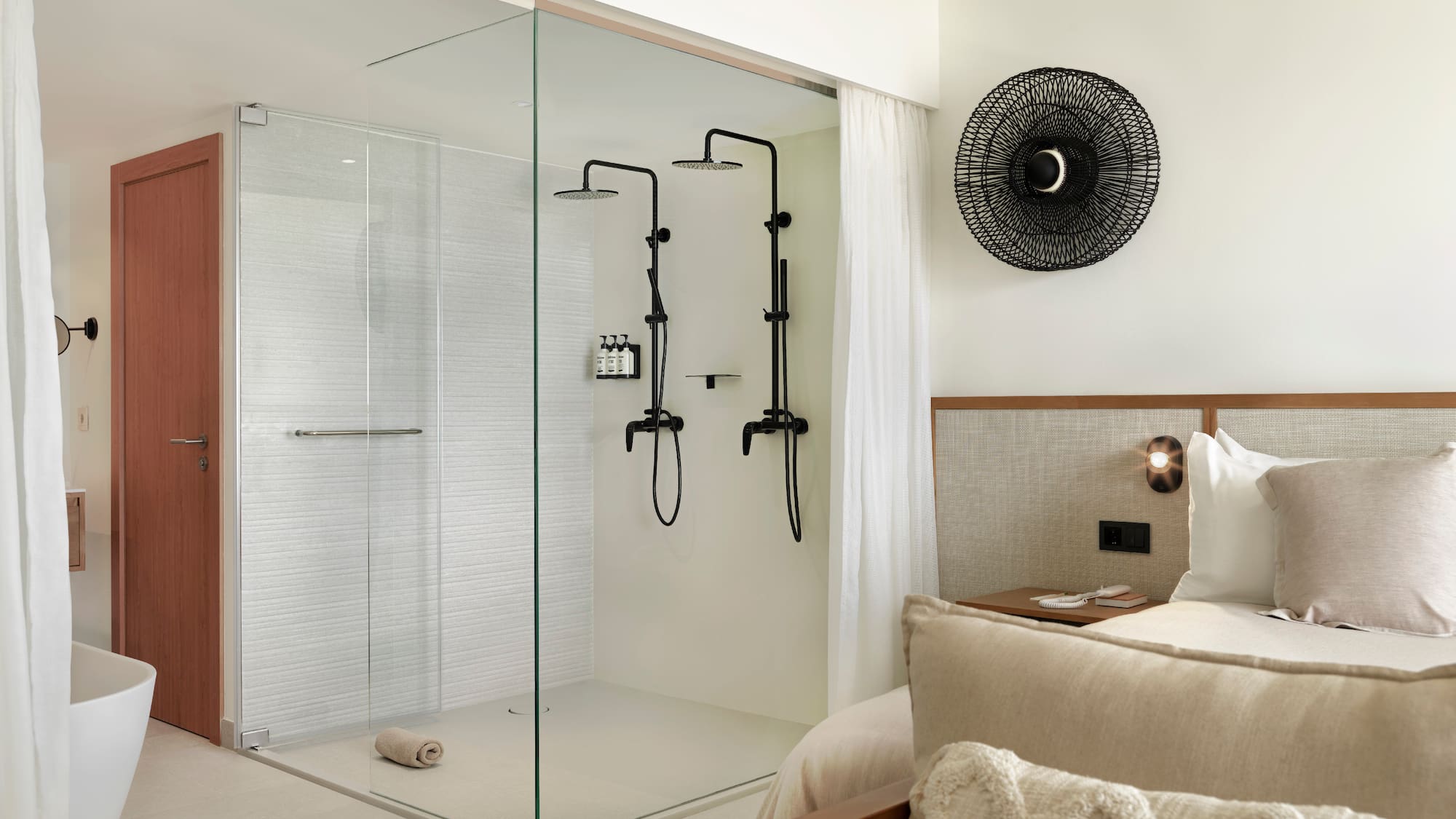 a room with a glass shower and a bed