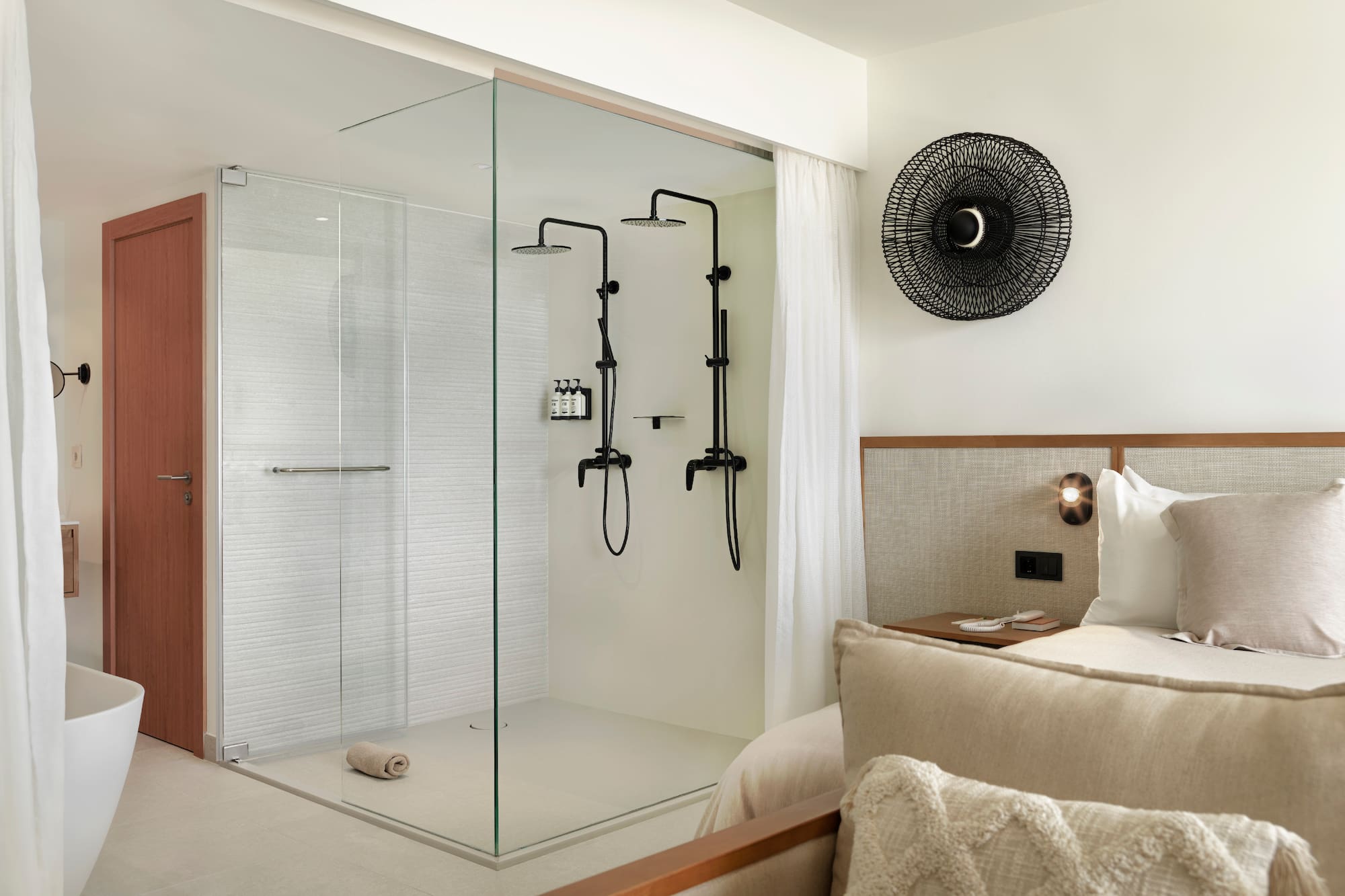a room with a glass shower and a bed