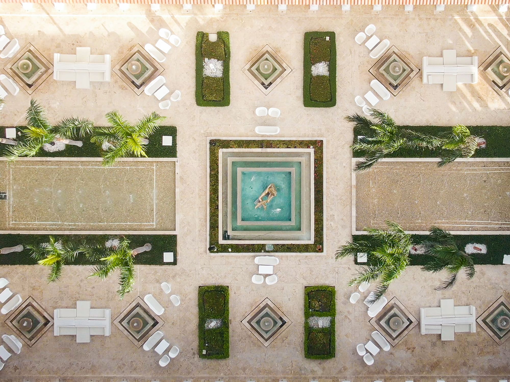 a courtyard with a pool and chairs