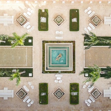 a courtyard with a pool and chairs