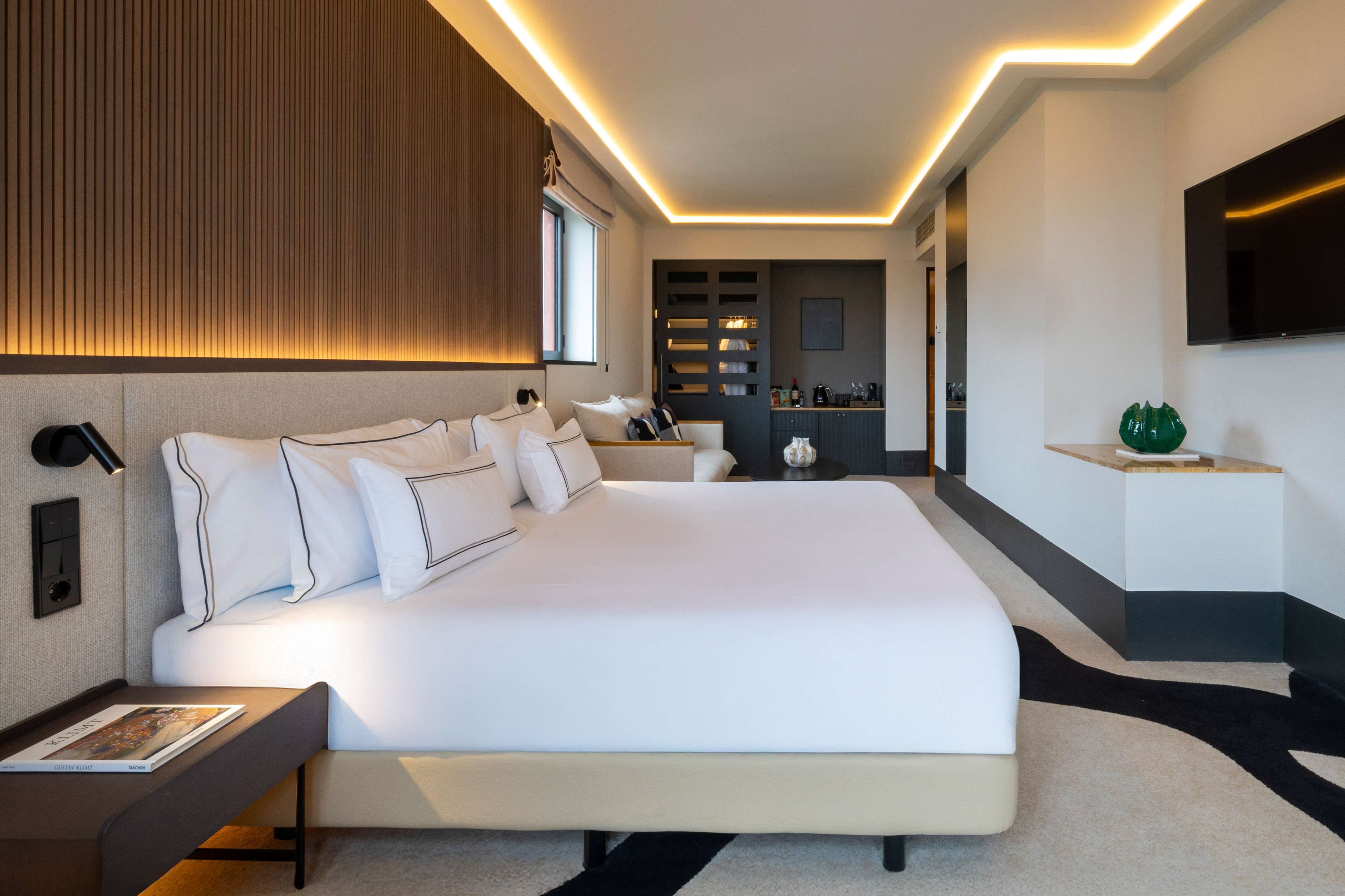 Luxury hotel room with king bed, modern design, and ambient lighting.