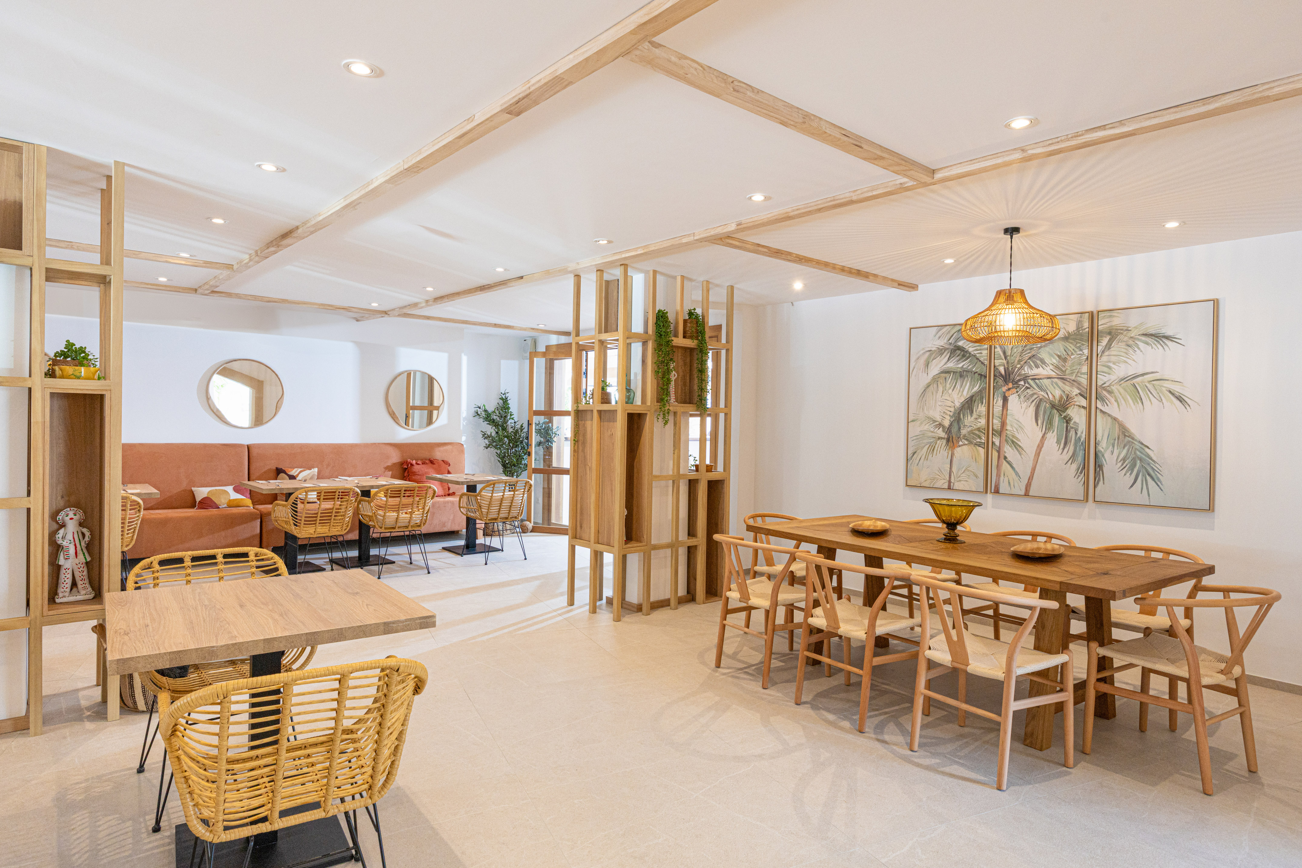 Modern restaurant, wooden tables, rattan chairs, tropical palm art.