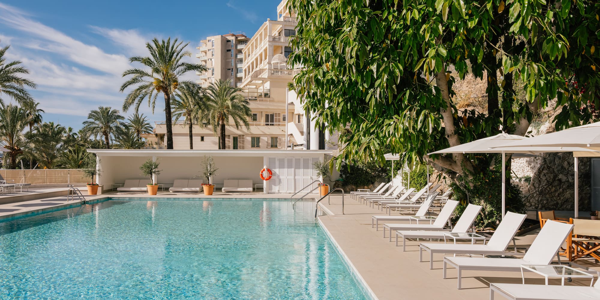 a pool with lounge chairs and trees