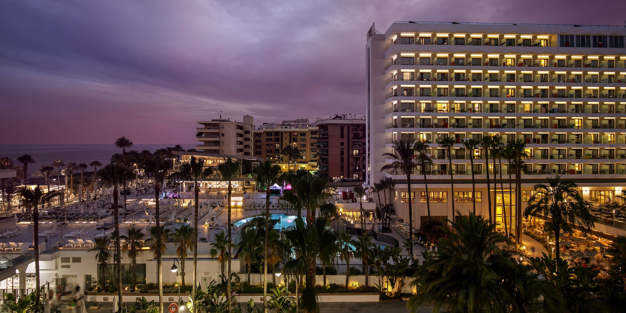 a pool and buildings with palm trees