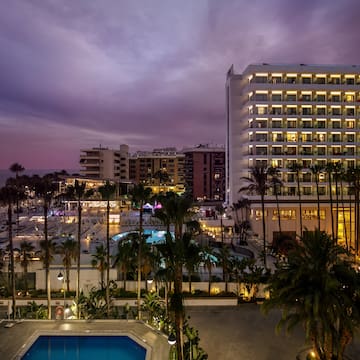 a pool and buildings with palm trees