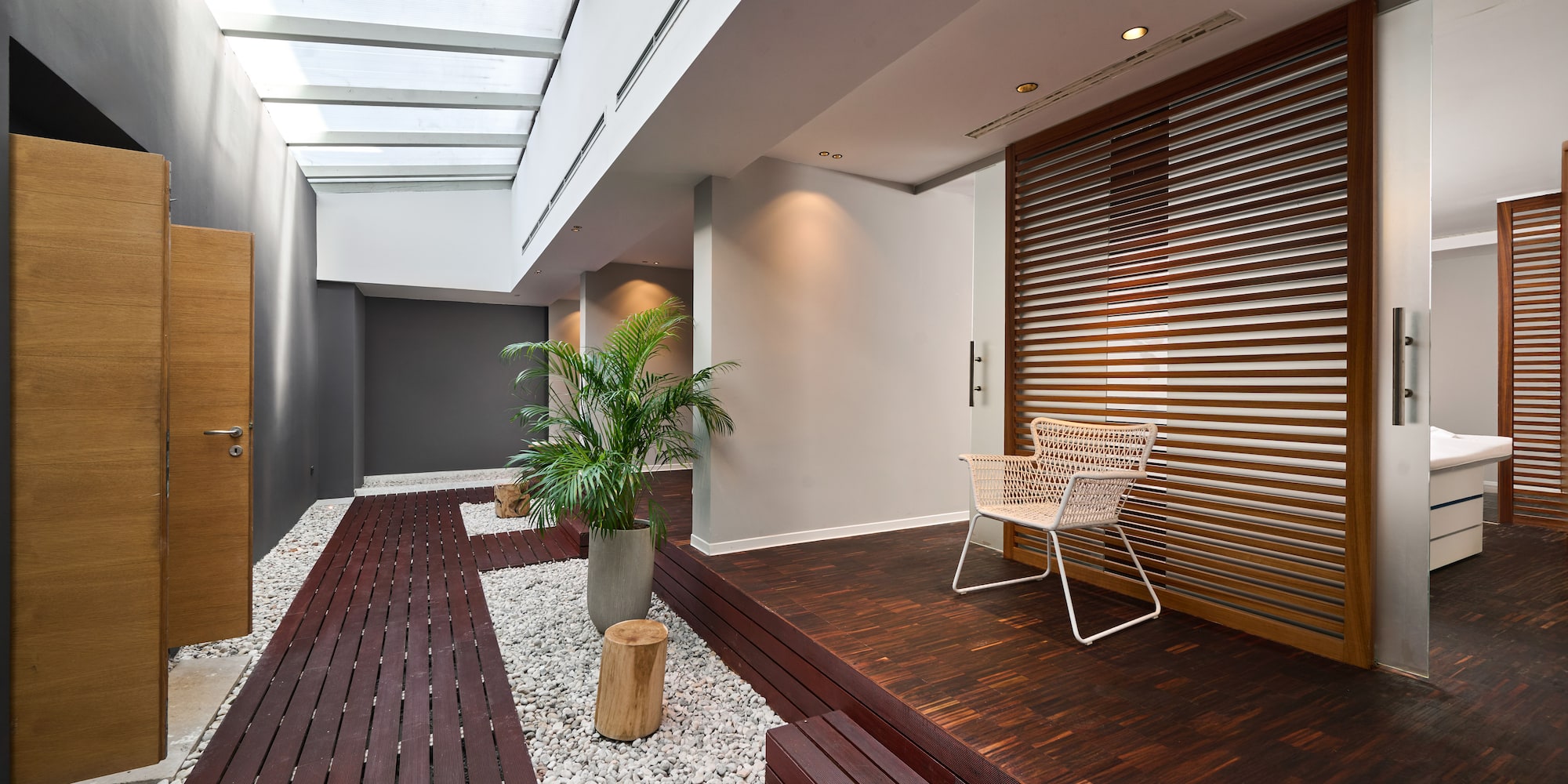a room with a white chair and a potted plant