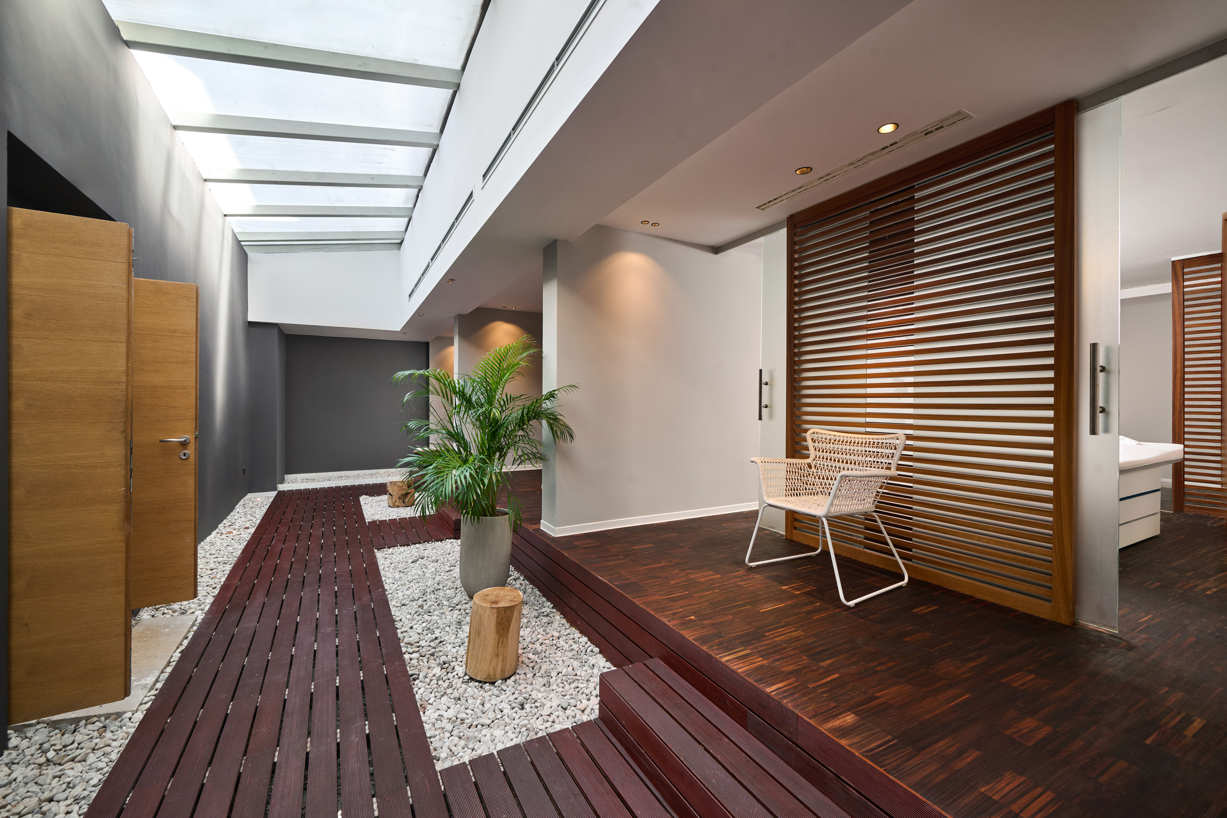 a room with a white chair and a potted plant