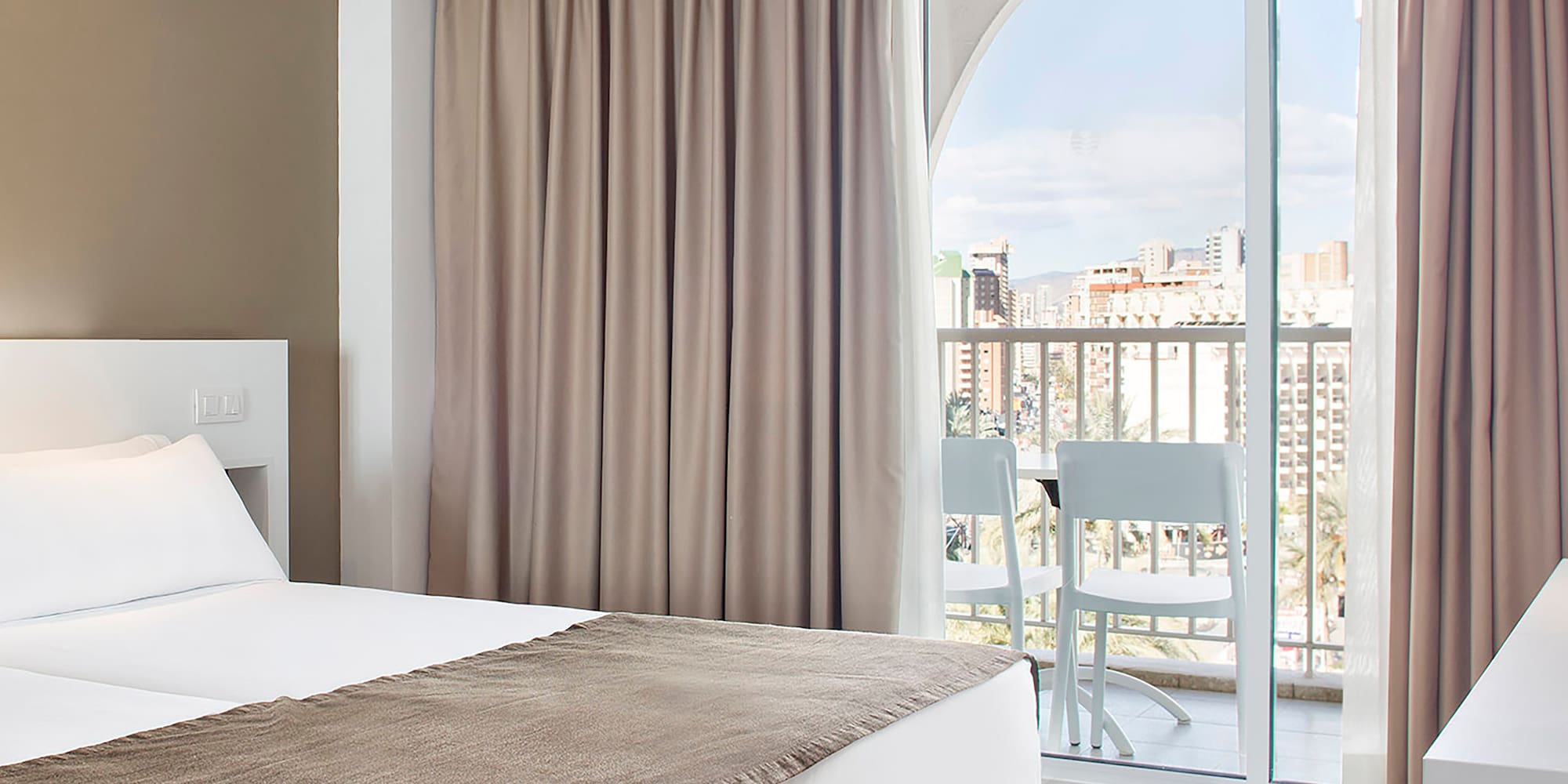 a room with two beds and a balcony