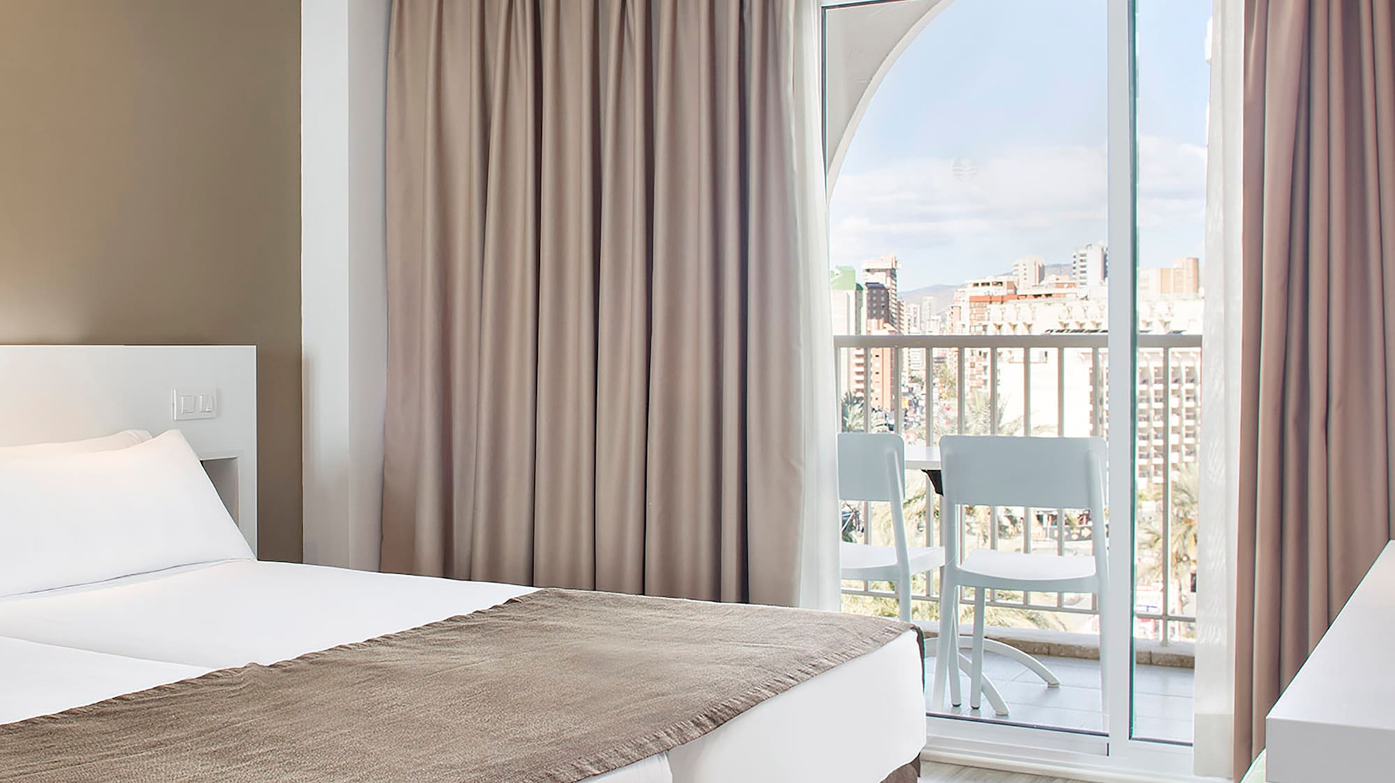 a room with two beds and a balcony