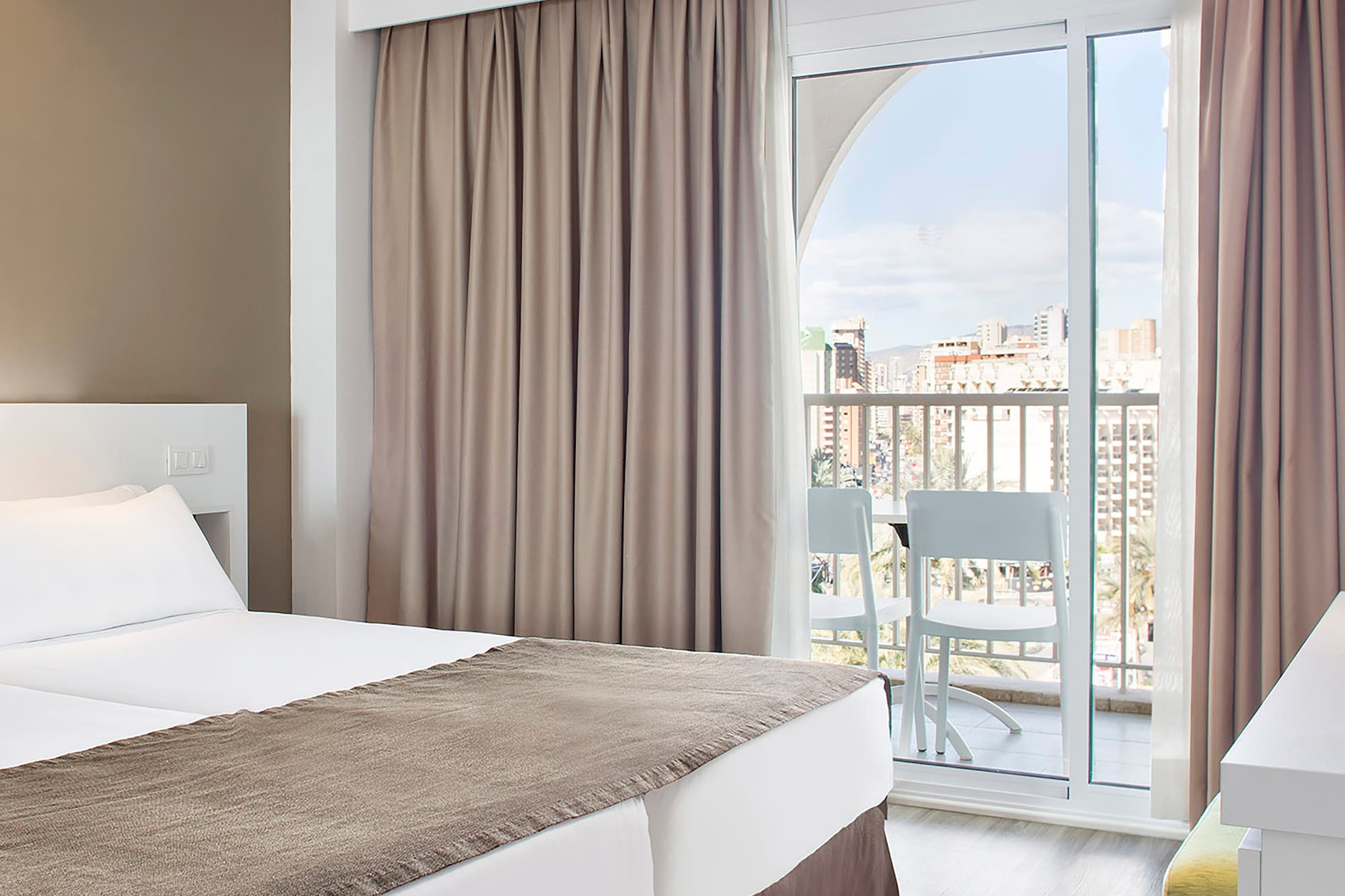 a room with two beds and a balcony