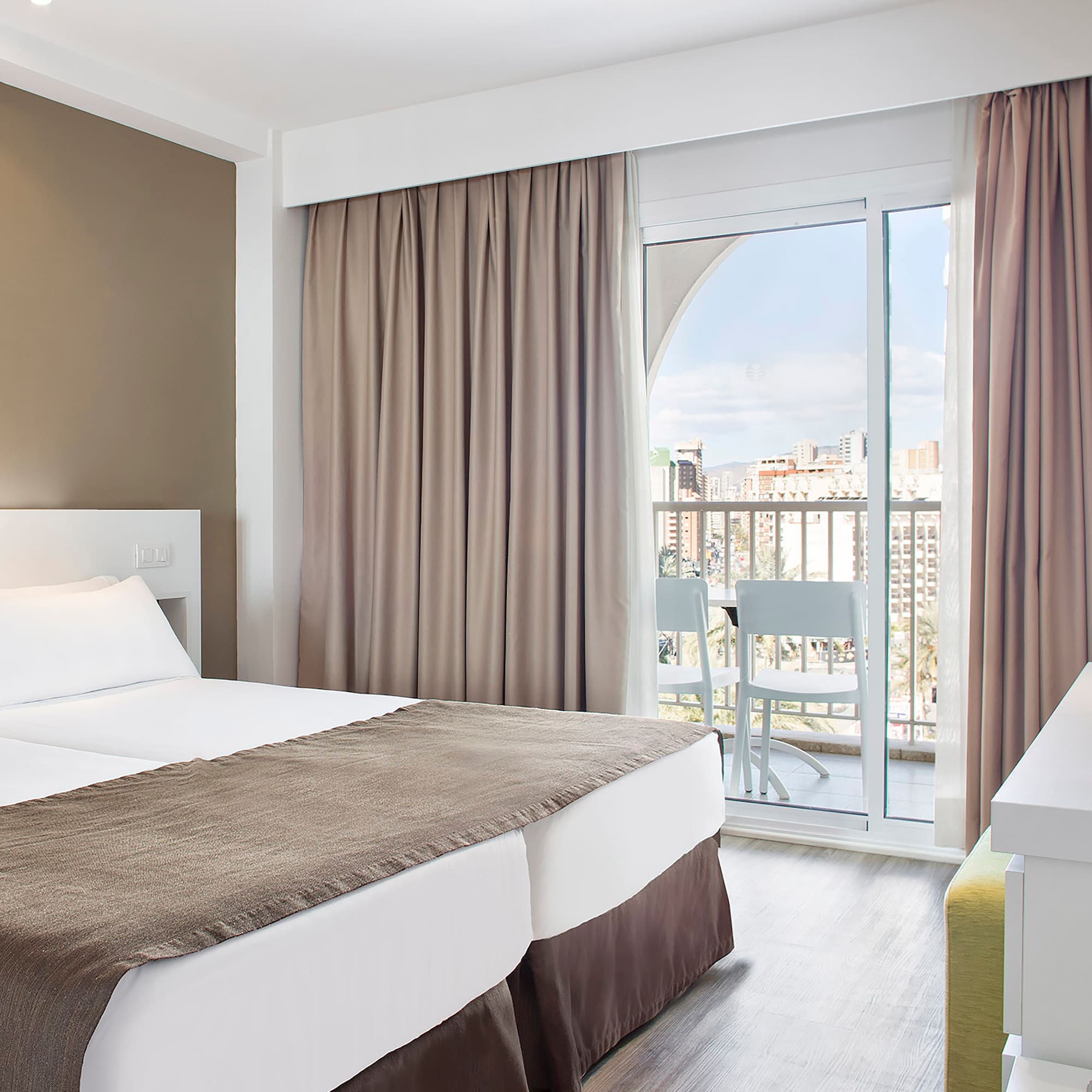 a room with two beds and a balcony