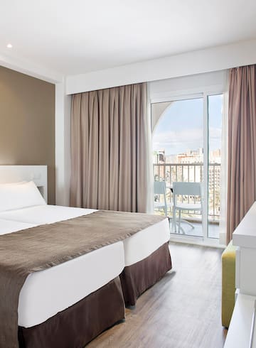 a room with two beds and a balcony