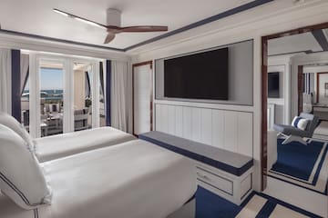 a room with two beds and a television