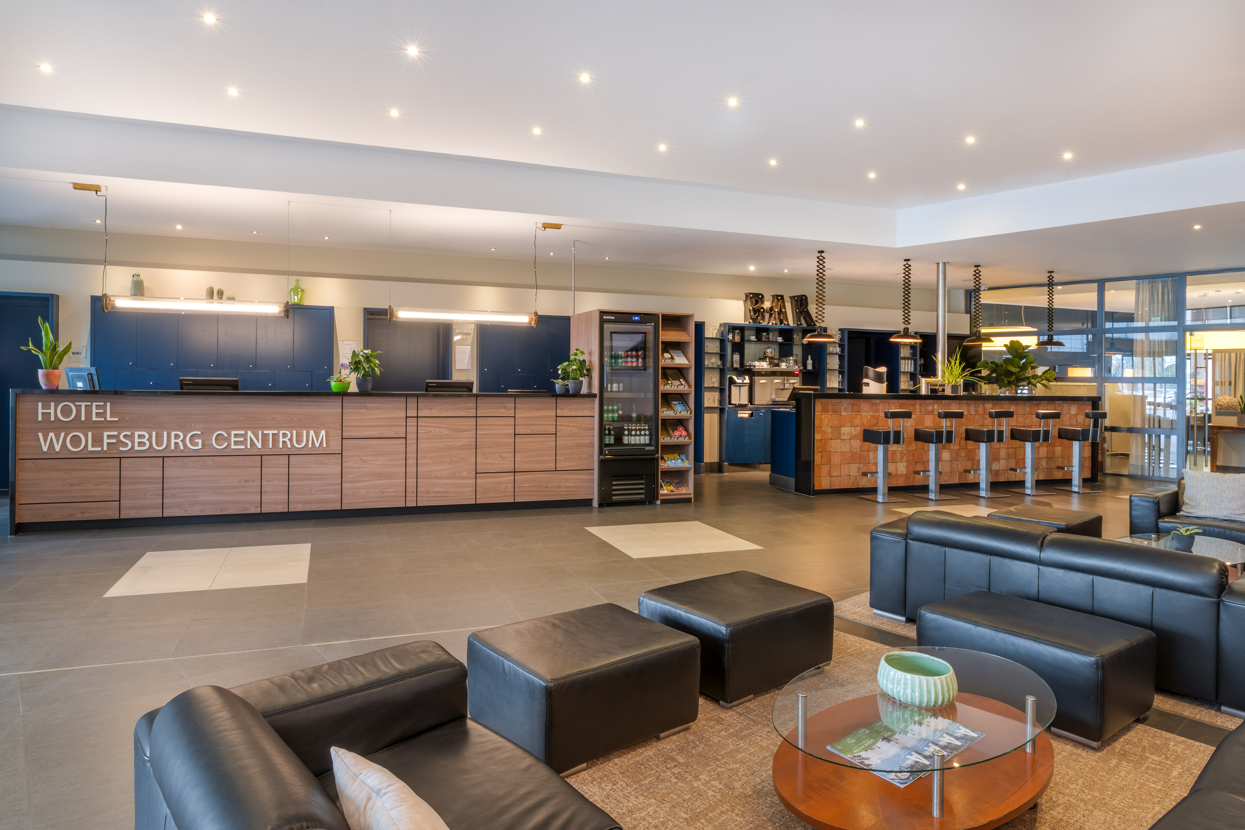 Hotel Wolfsburg Centrum lobby with reception desk, bar, and modern seating.