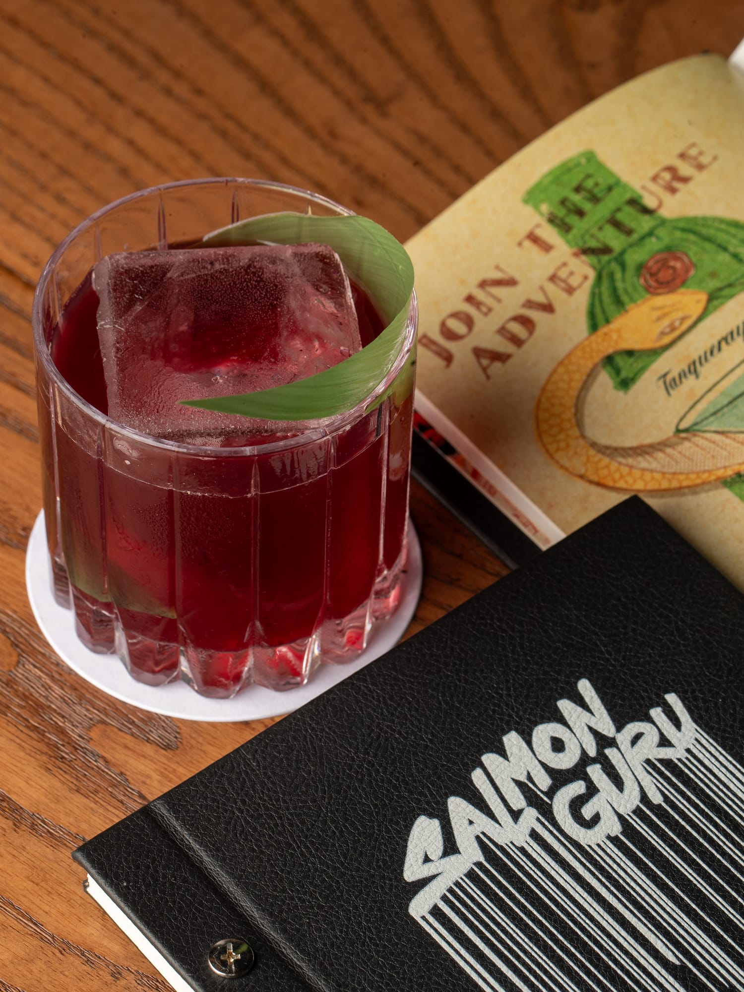 a drink in a glass next to a book