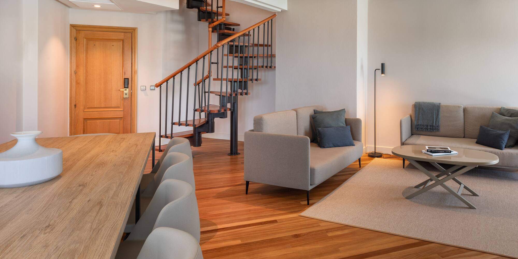 a living room with a spiral staircase and couches