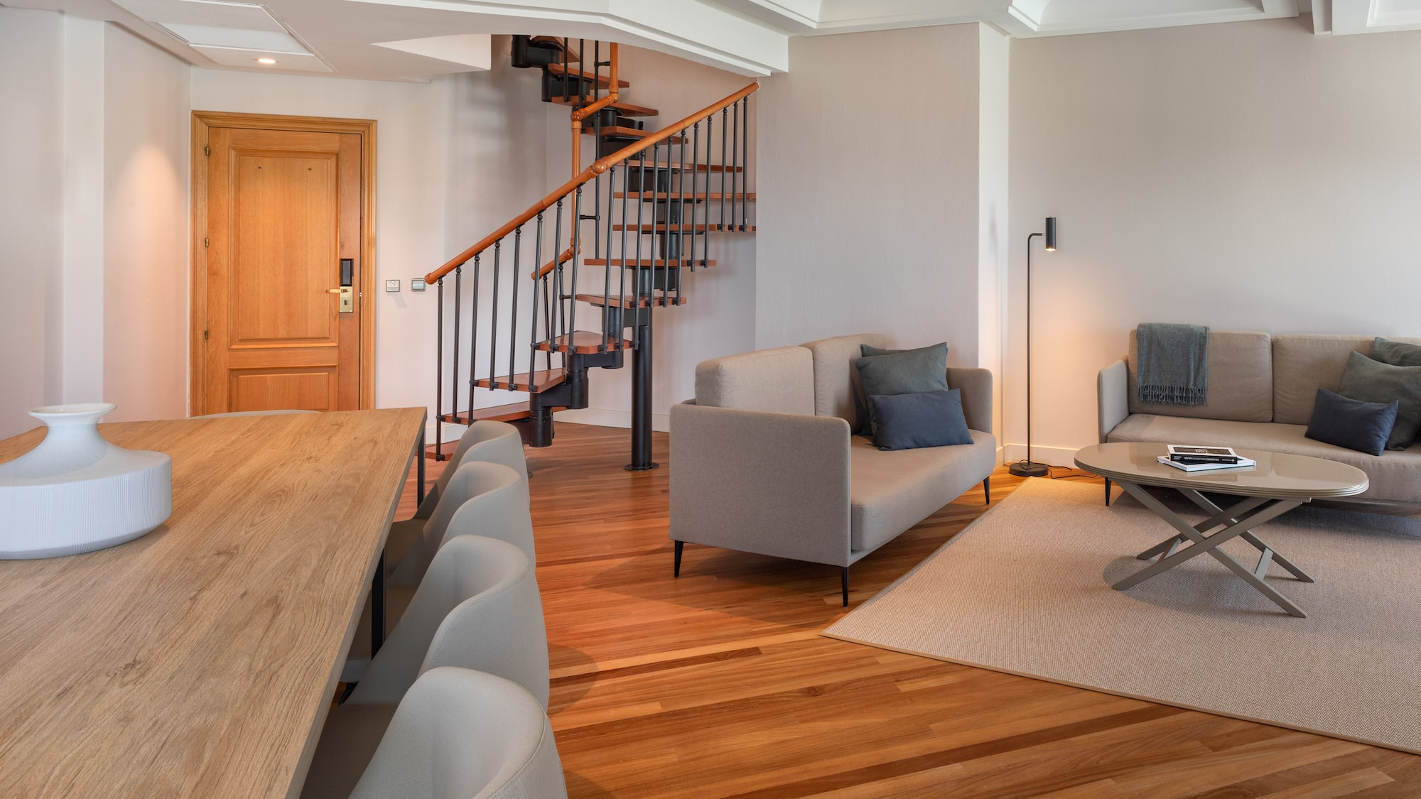 a living room with a spiral staircase and couches