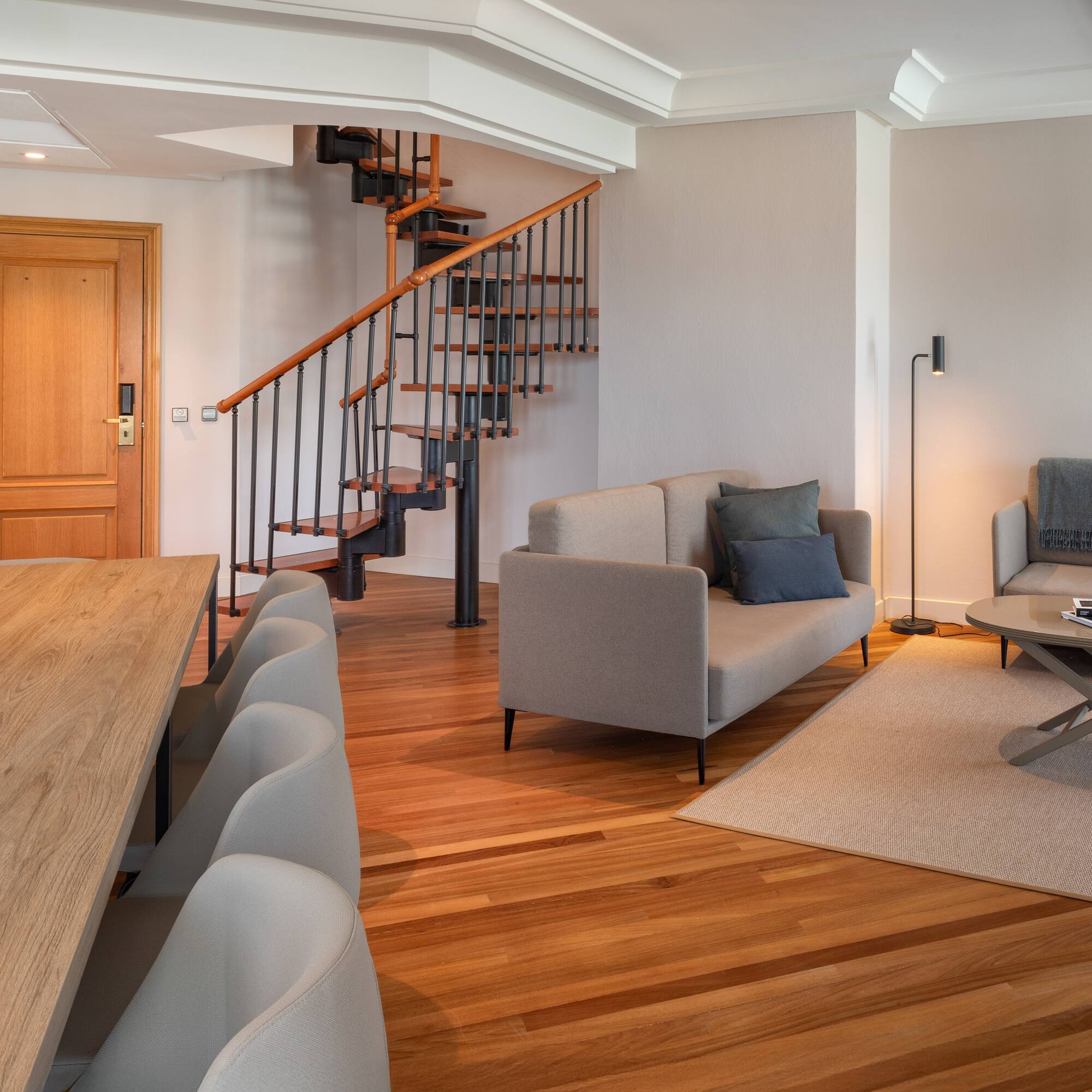 a living room with a spiral staircase and couches