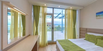 a bedroom with green curtains and a window